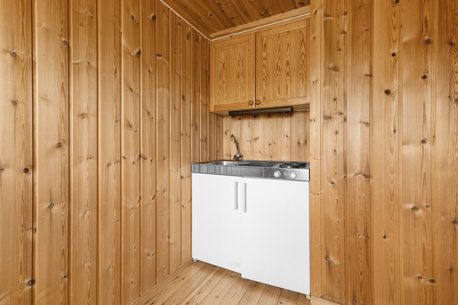 Kjøkken i underetasjen er innredet med enkelt hybelkjøkken med vask og to stekeplater, over er det montert skap og kullfilter ventilator. Galleribilde