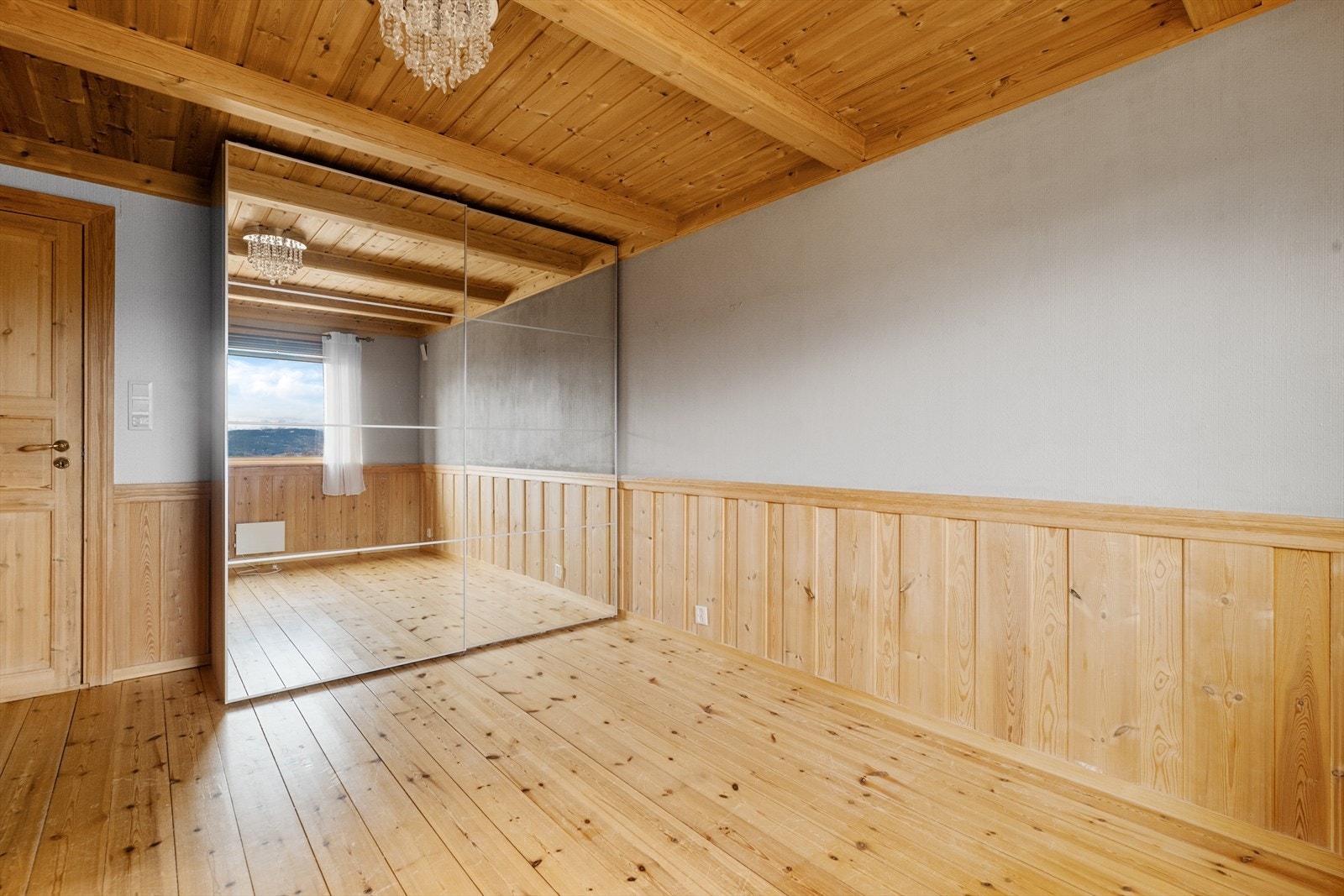 Det ene soverommet har romslig garderobe med speilfronter, her er det dør med direkte tilkomst til badet. Galleribilde