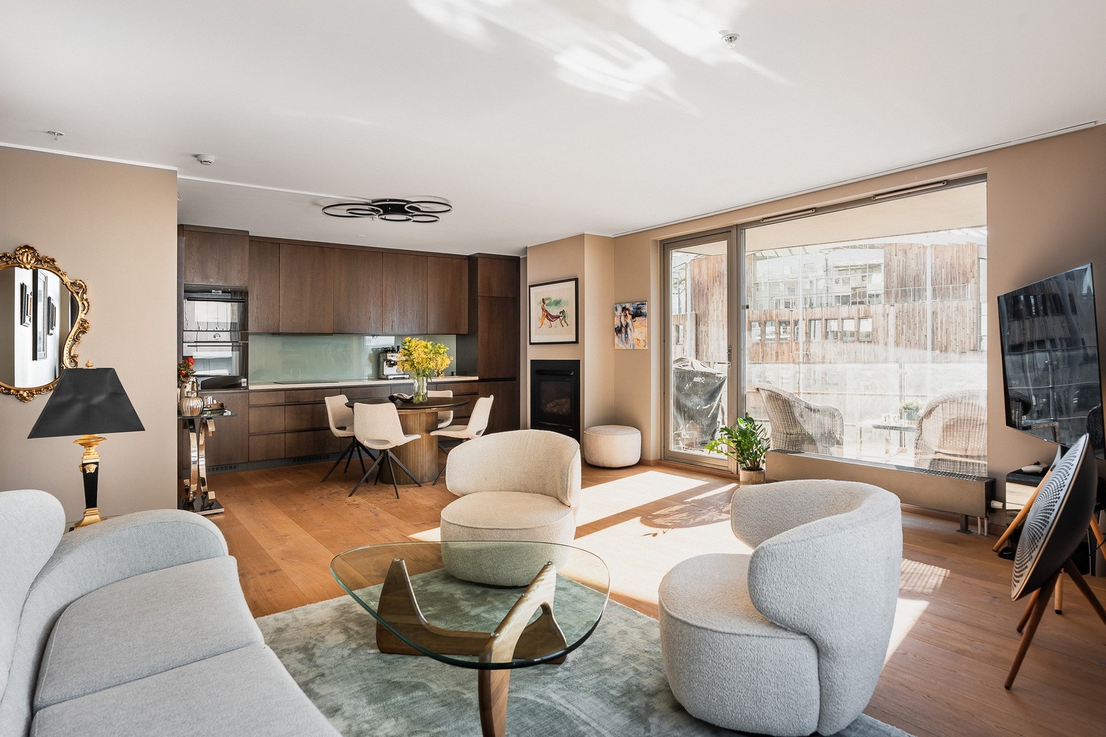 Velkommen til Olav Selvaags Plass 4! Her ser du leilighetens åpne løsning som forener stue, spisestue og kjøkken i en moderne og elegant ramme. Galleribilde