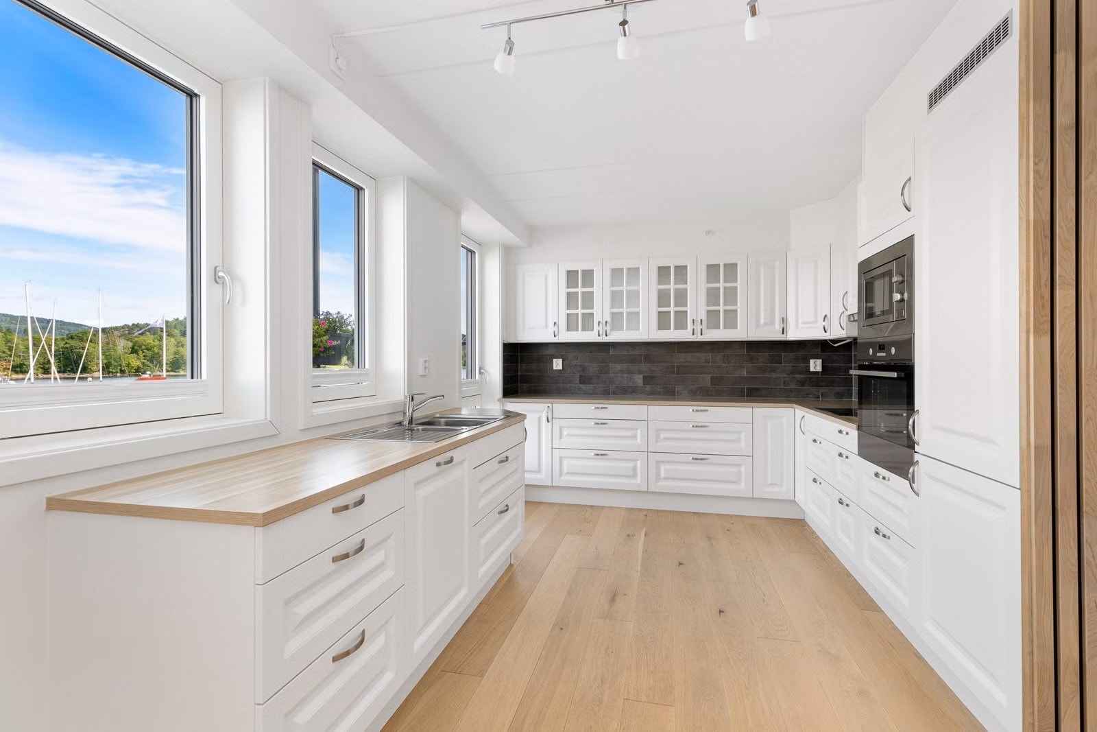 Kjøkkenet har kjøkkeninnredning med hvite profilerte fronter fra merket Aubo Galleribilde