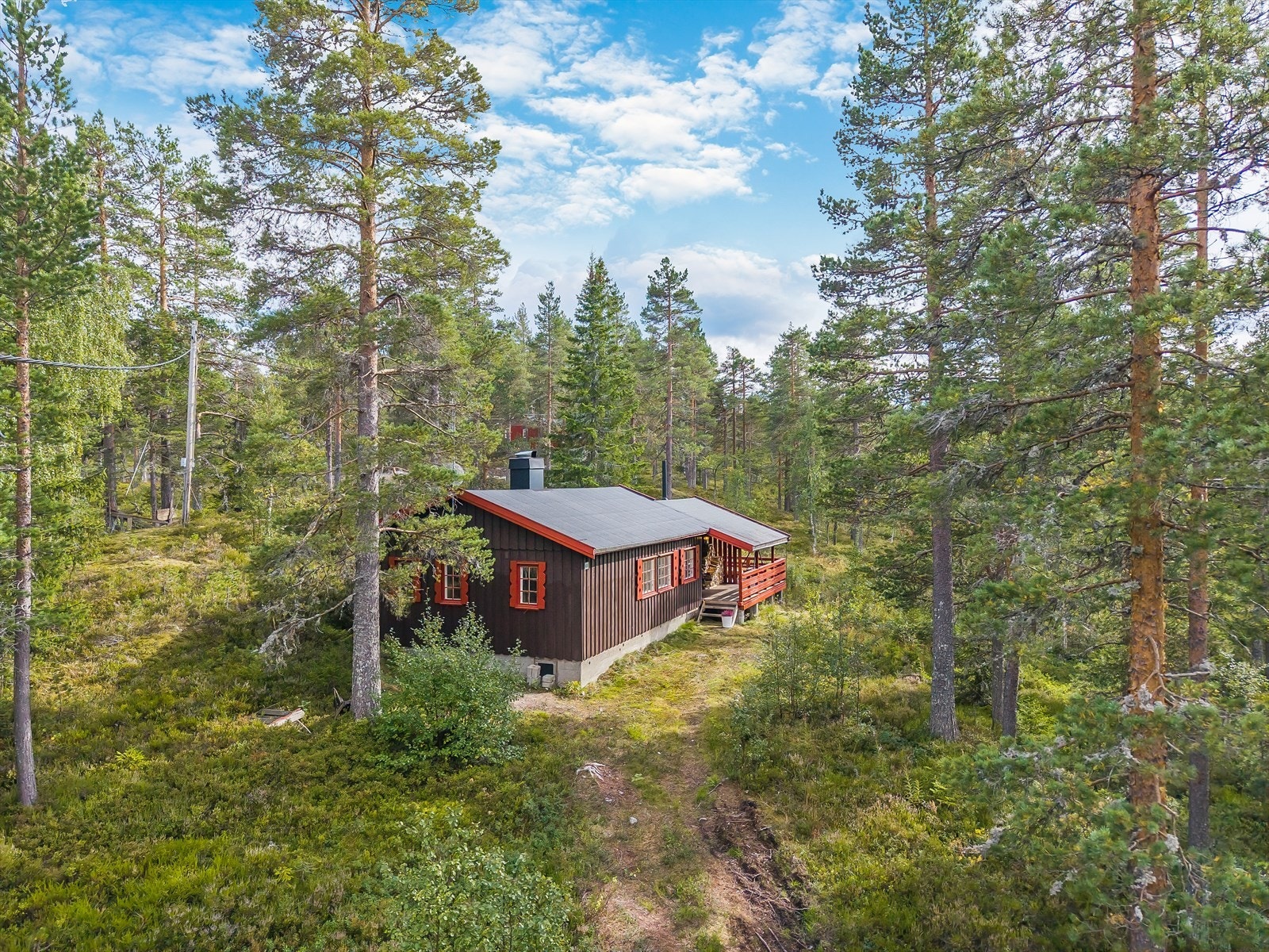 Eiendommen har adkomst via privat helårsveg, med biloppstillingsplass ca. 40 m i lett skrånende terreng nedenfor hytta. Galleribilde
