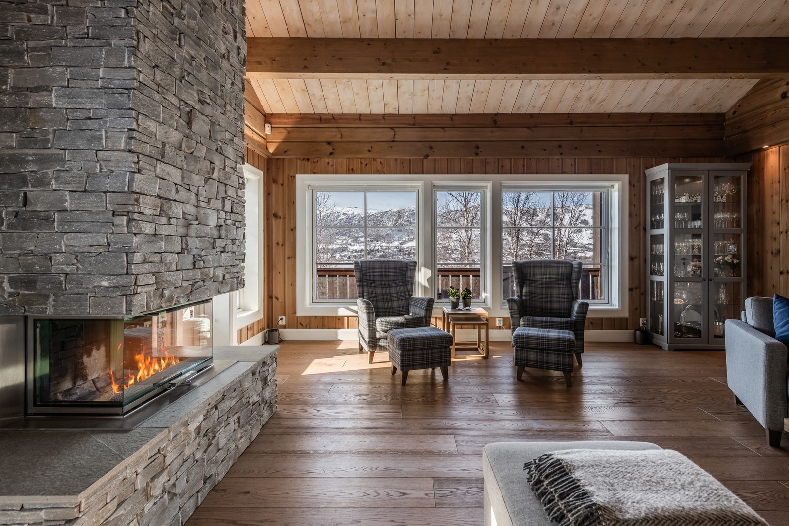 Store vindusflater og peis som skaper en lun og eksklusiv hyttefølelse Galleribilde