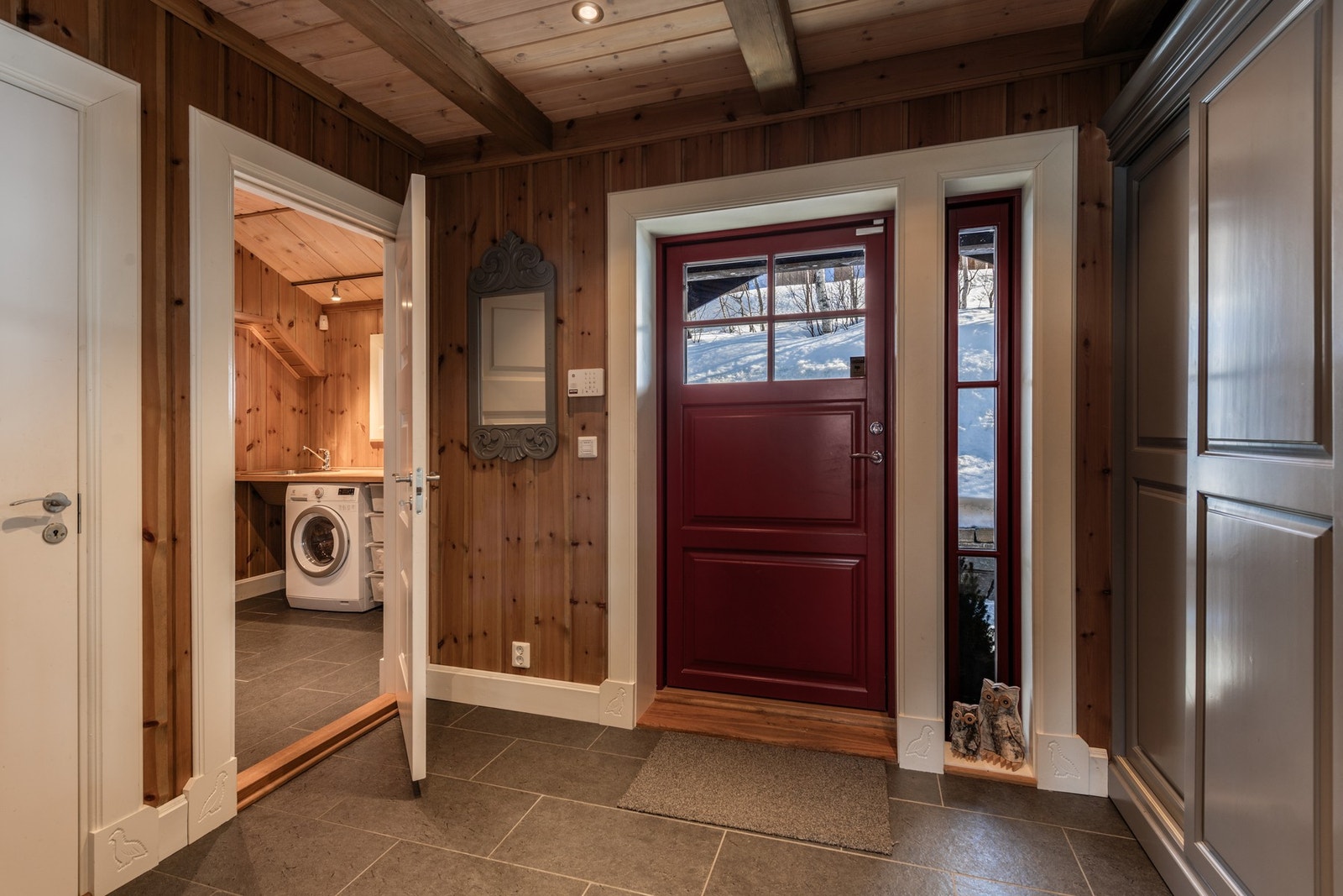 Entreen har flislagt gulv, godt med garderobeplass samt dører til vaskerom og toalett Galleribilde