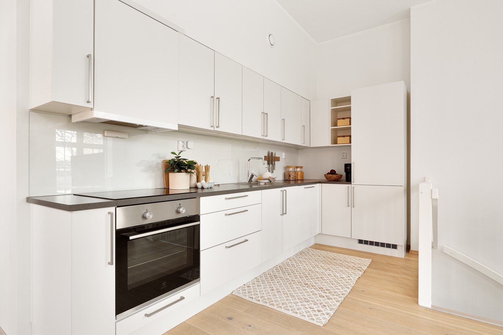 Kjøkkenet er lyst og moderne med slette fronter og integrerte hvitevarer. Galleribilde