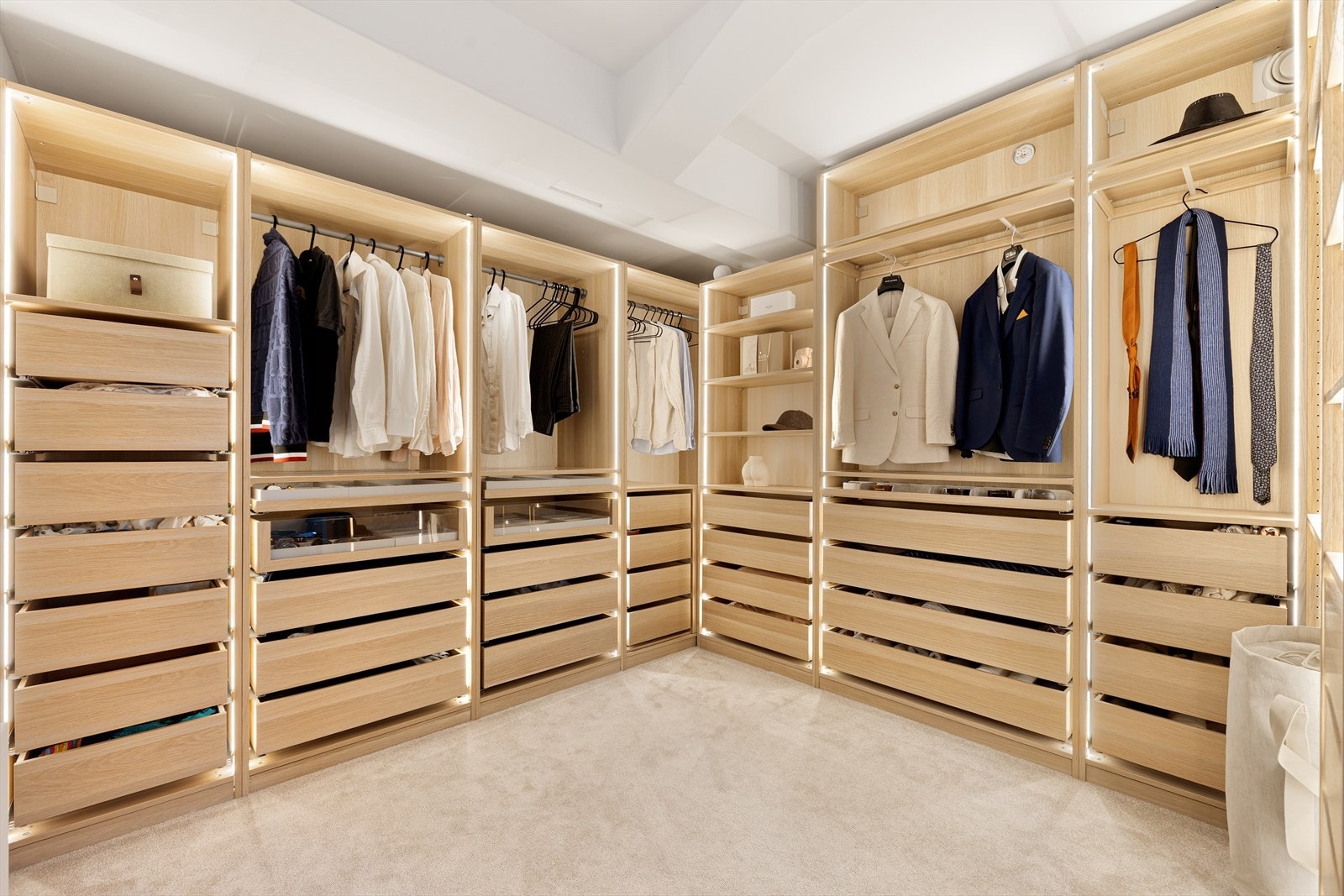 Delikat walk-in-closet med elegant belysning og oversiktlig oppbevaring. Galleribilde