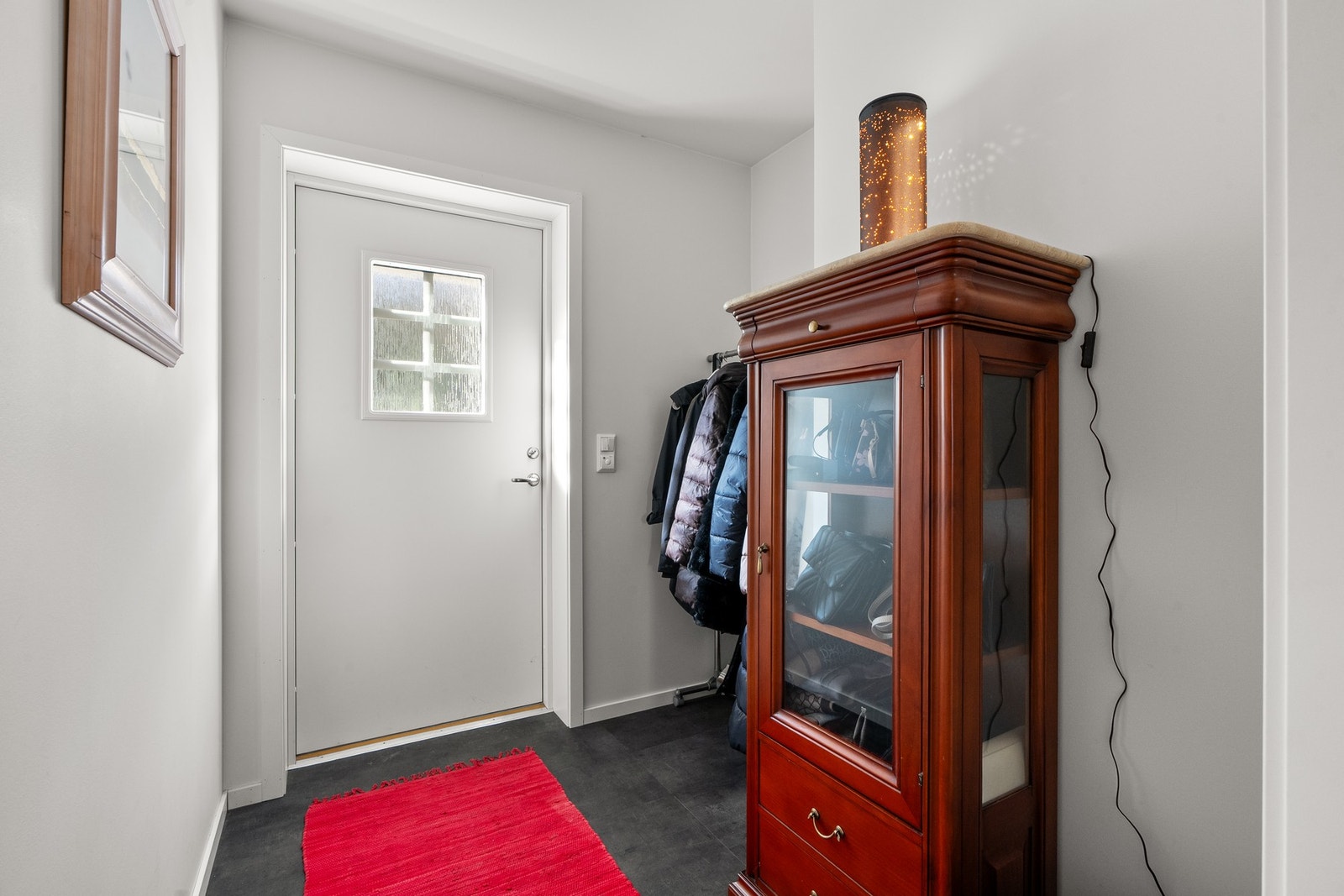 Du ønskes velkommen inn i en lys entré med plass til sko og oppheng av yttertøy. Entréen har god standard fra 2021 med mørk laminat på gulv, gulvvarme og glatte lysmalte overflater. Galleribilde