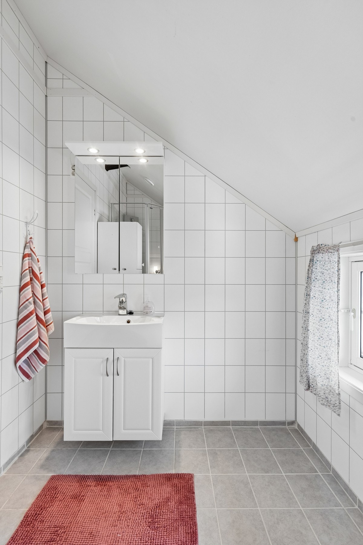 Bad i andre etasje er også flislagt med vegghengt innredning, stående toalett og dusjkabinett Galleribilde