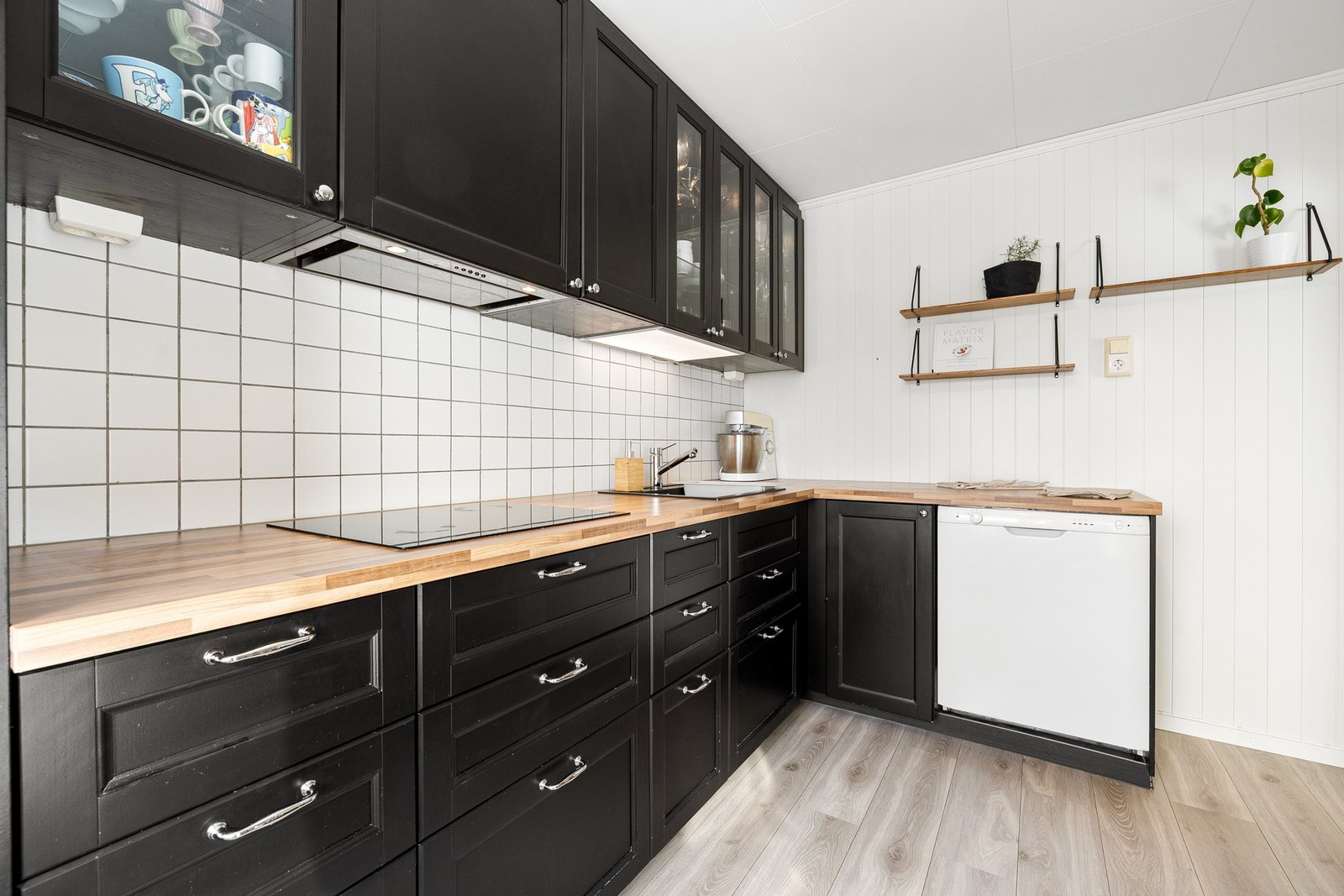 Kjøkkeninnredning i laminert utførelse med profilerte fronter og laminert benkeplate med nedfelt koketopp og vaskekum. Galleribilde