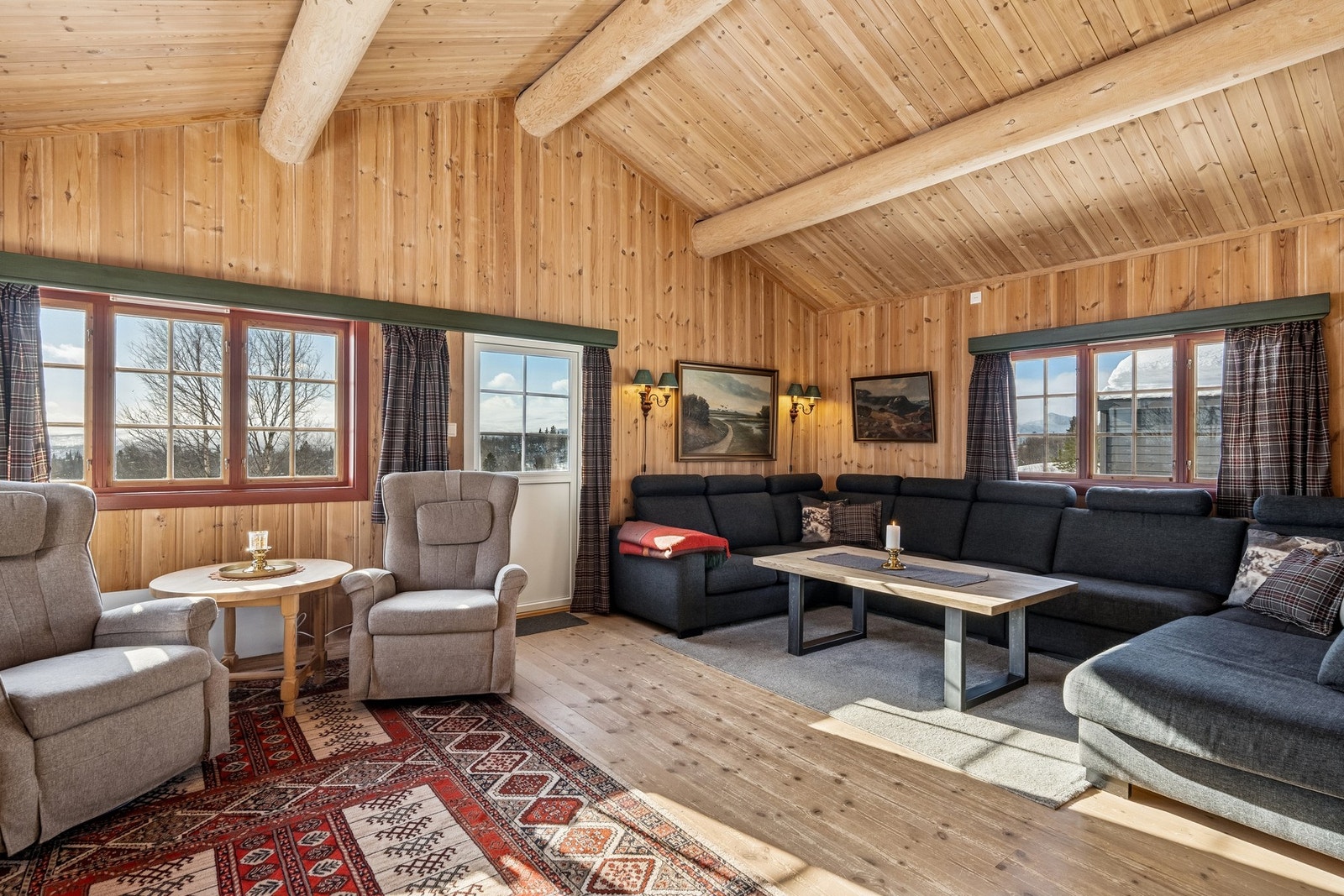 Rommet har god takhøyde med tømmeråser. Utgang til terrassen Galleribilde