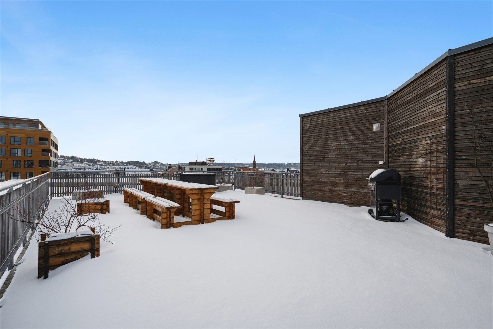 Felles takterrassen på toppen av bygget med sittebenker og grill. Galleribilde