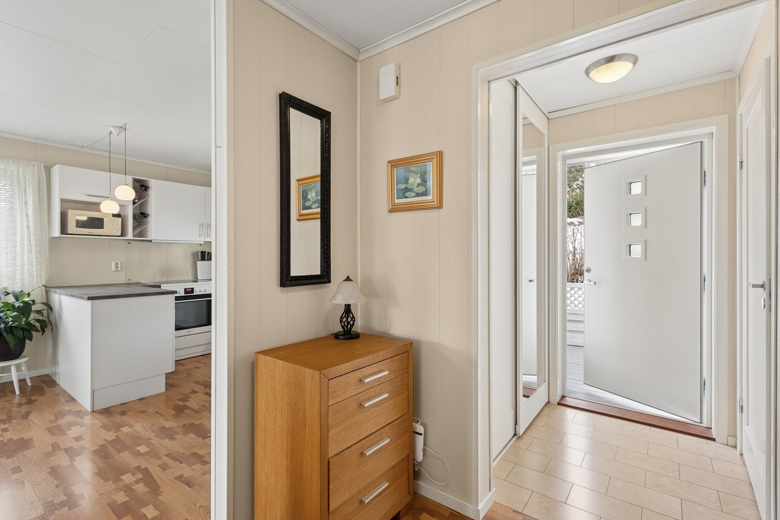 Entréen i hovedetasjen har flislagt gulv og oppbevaring i skyvedørsgarderobe. Galleribilde