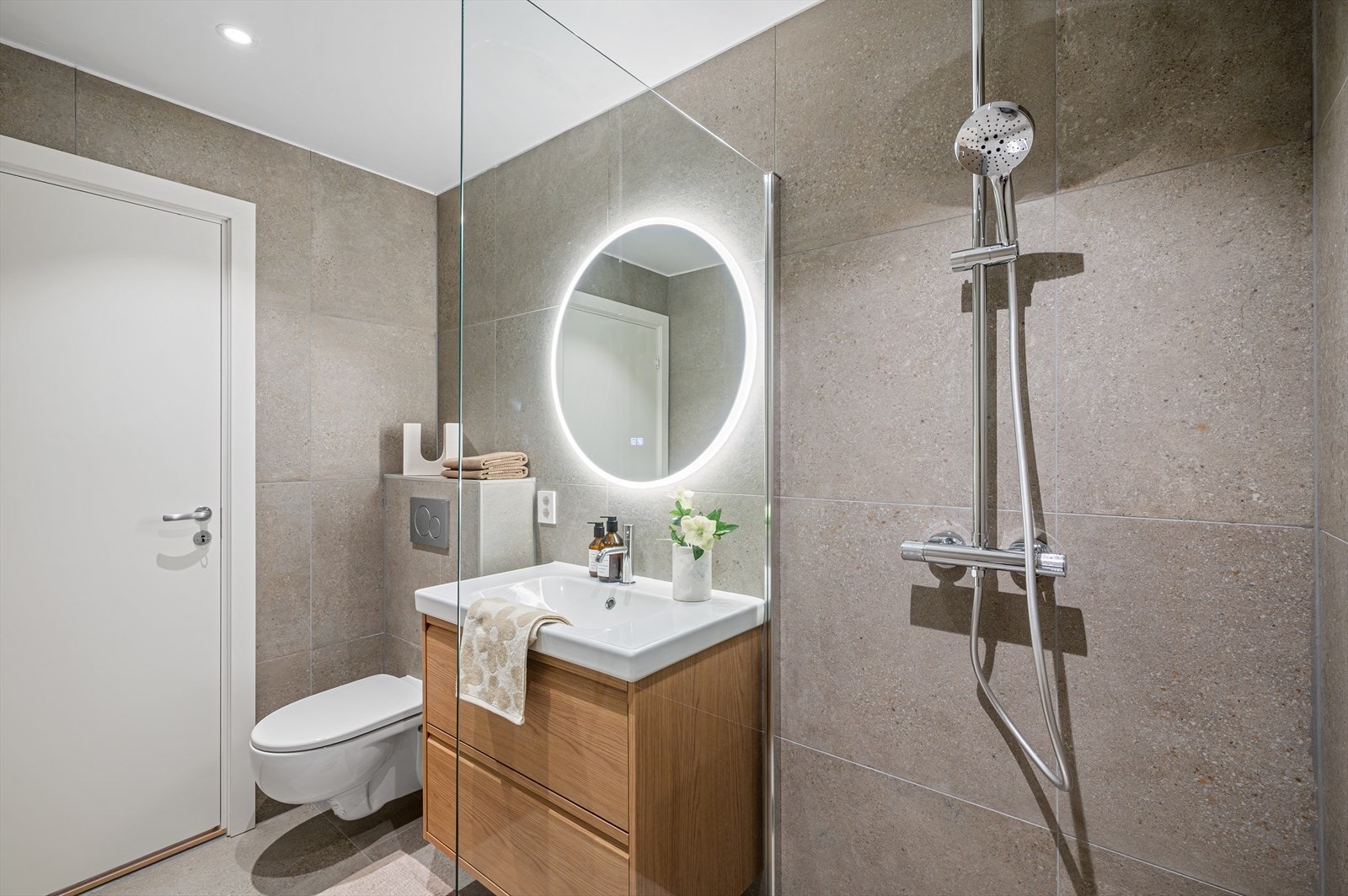 - Innredet med vegghengt toalett, benkeskap med servant og dusjvegg i glass. Varme i gulvet - Galleribilde