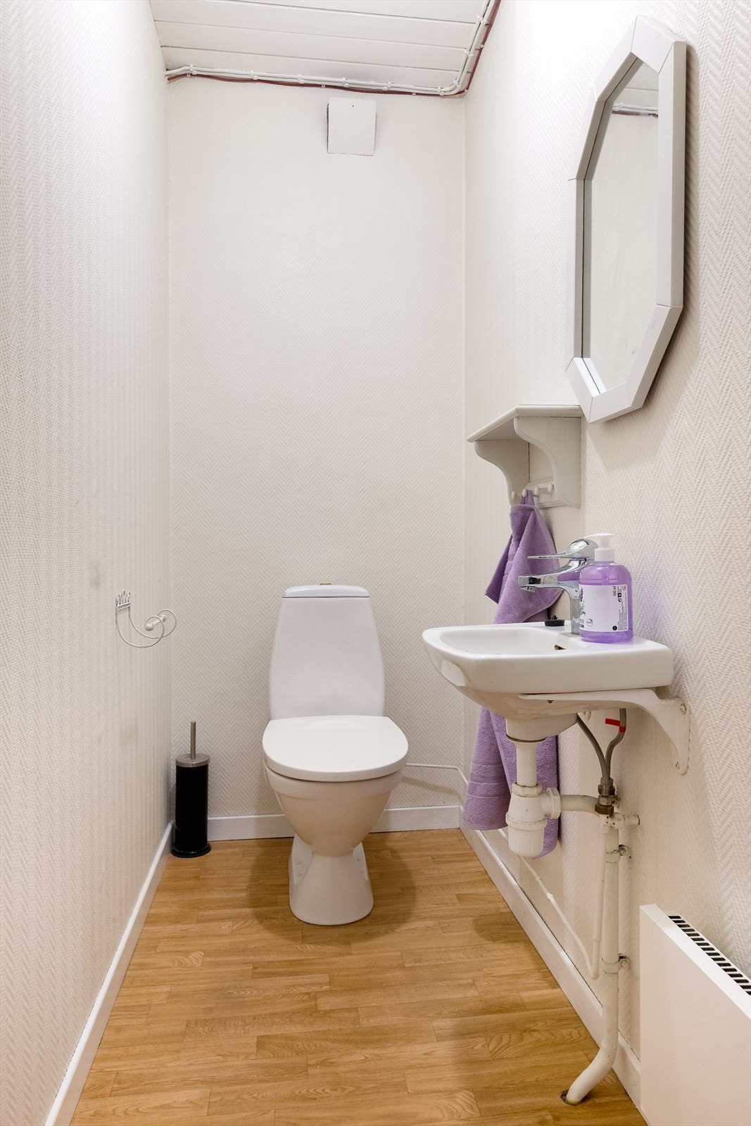 Toalettrommet innehar toalett og servant på vegg. Galleribilde