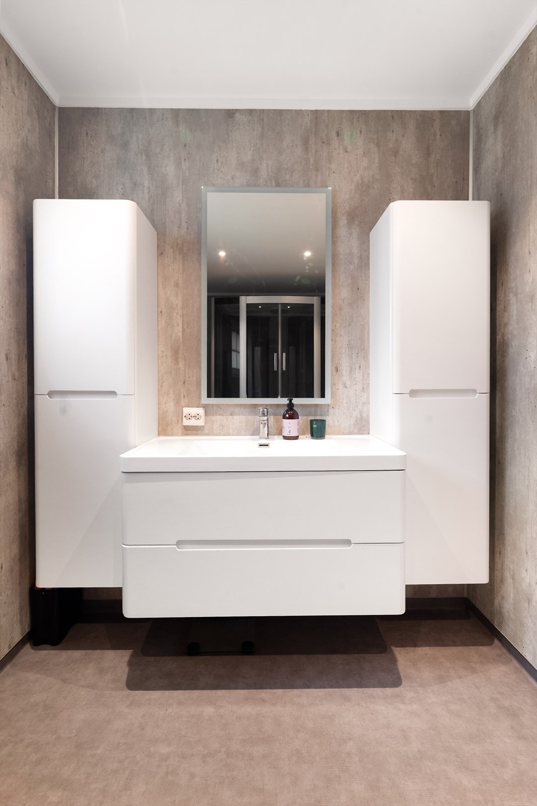 Badet har vinylbelegg med varmekabler i gulv og baderomsplater på vegger. Det er elektrisk styrt vifte på vegg. Galleribilde