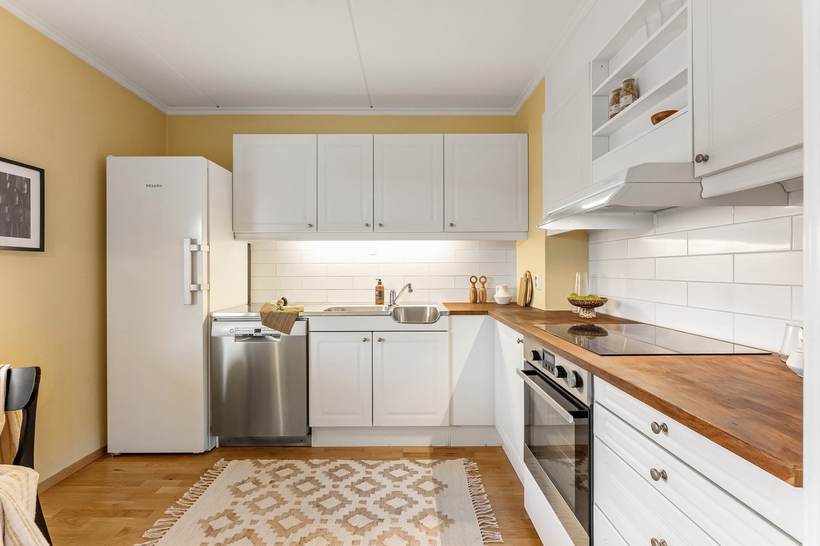 Kjøkkenet har innredning med profilerte fronter og benkeplate i heltre. Galleribilde