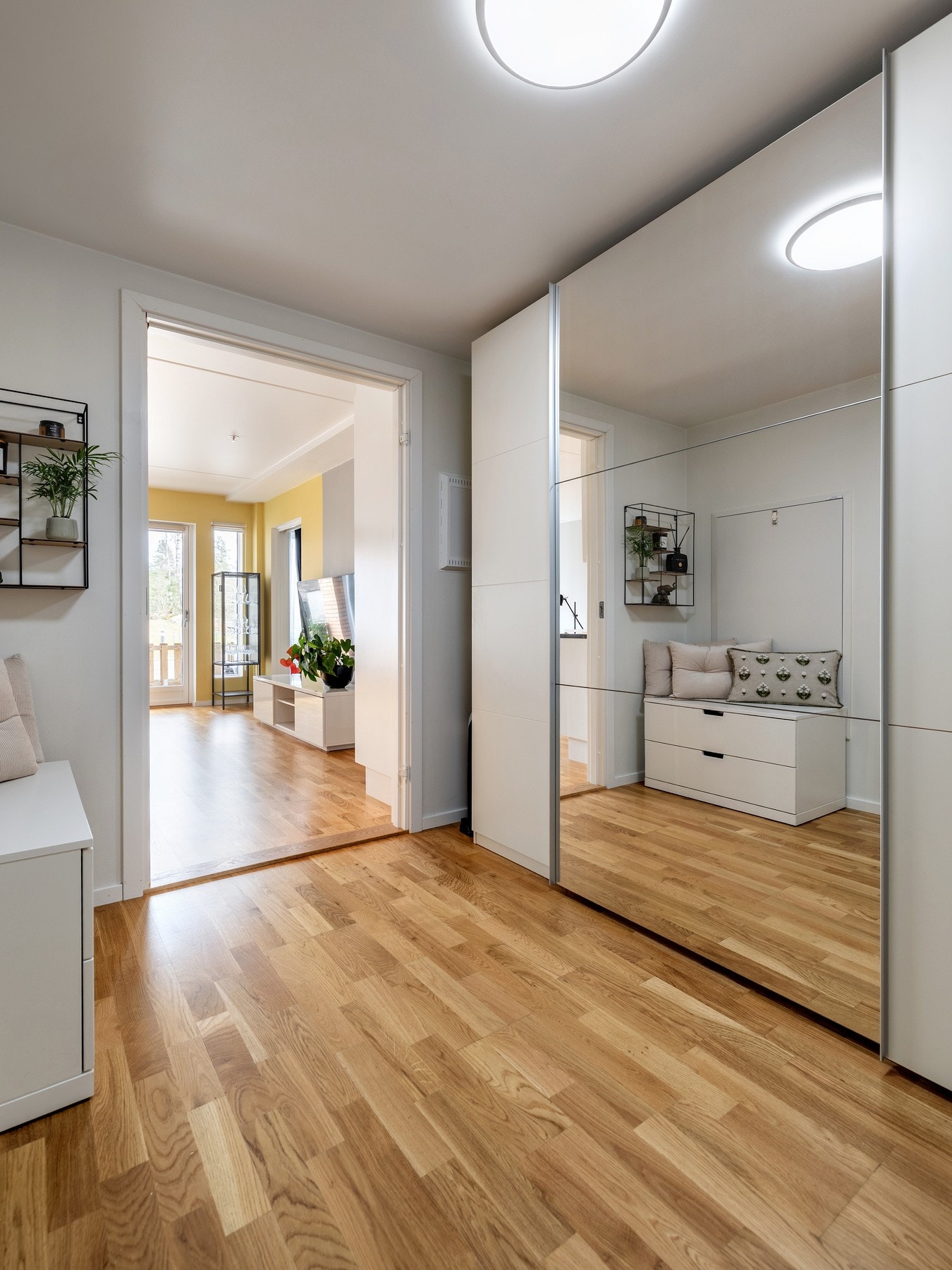 Entréen er innredet med en stilfull skyvedørsgarderobe med speilfronter for oppbevaring av klær, sko og annet utstyr. Galleribilde