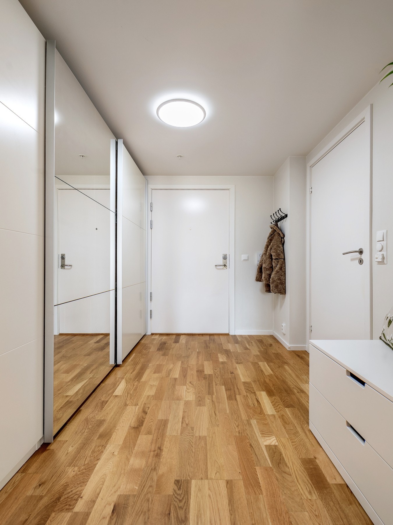 Entréen gir et godt førsteinntrykk av leiligheten med lysmalte vegger og trestavs parkett. Galleribilde