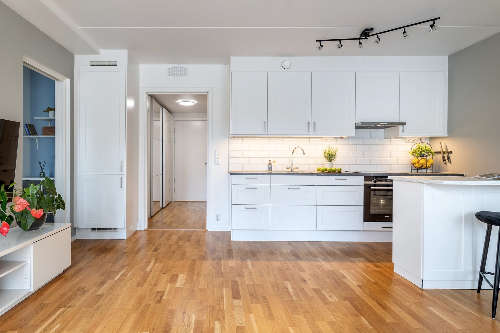 Stilren kjøkkeninnredning med lyse fronter og laminerte benkeplater med nedfelt oppvaskkum. Galleribilde