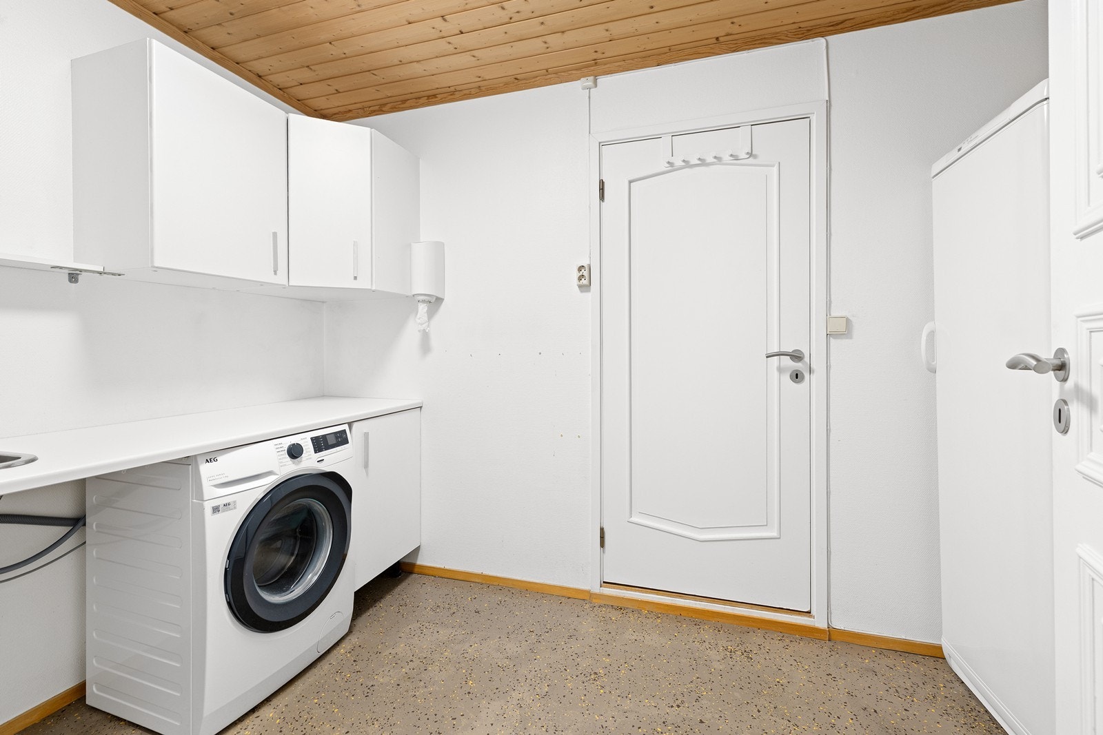 Praktisk vaskerom med opplegg for vaskemaskin, utslagsvask og gode arbeidsflater. Galleribilde