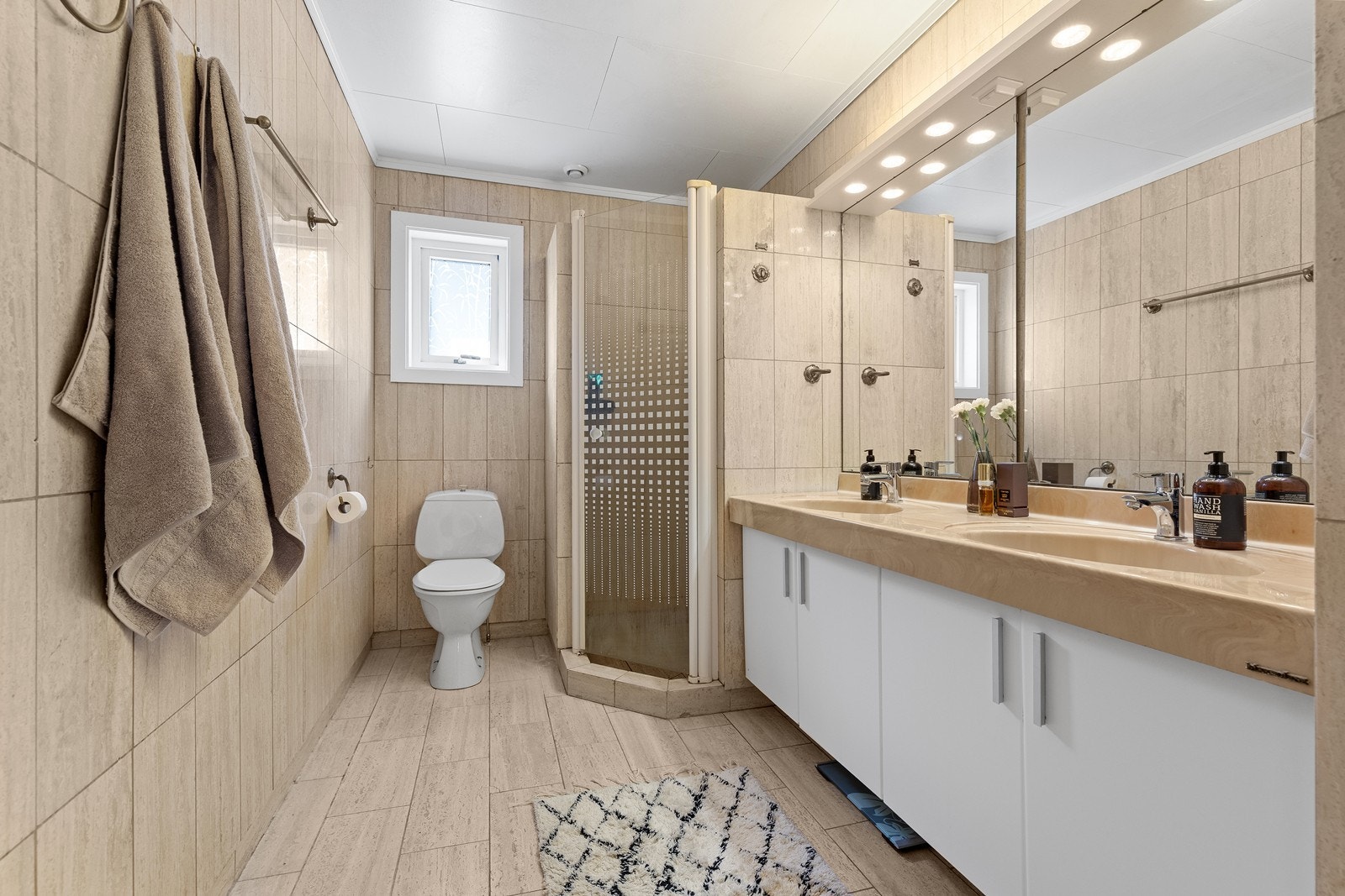 Flislagt bad med funksjonell planløsning og plass til hele familien i en travel hverdag. Galleribilde