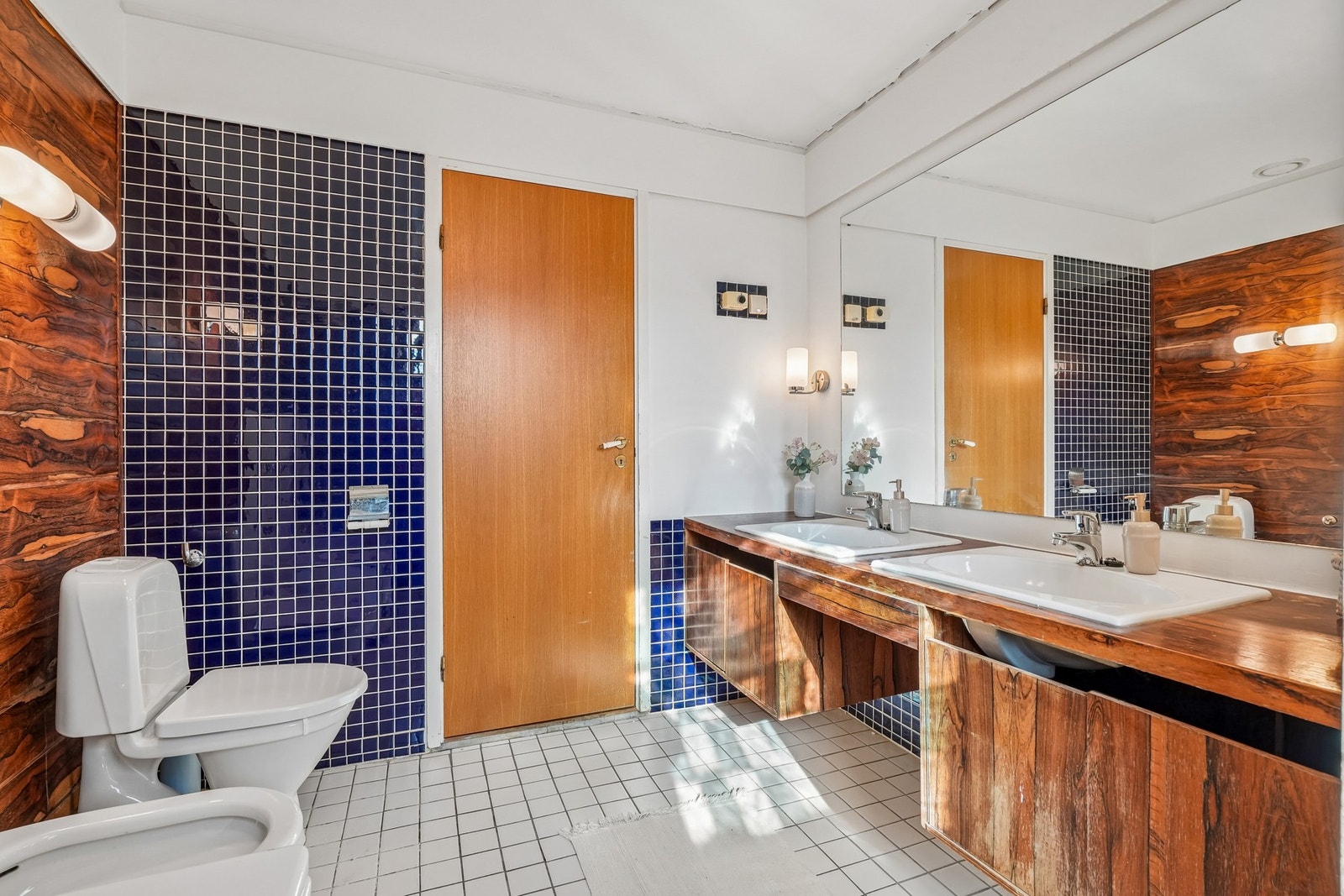 Innredet med servantinnredning, to porselensservanter, speil, badekar, toalett og bide. Galleribilde