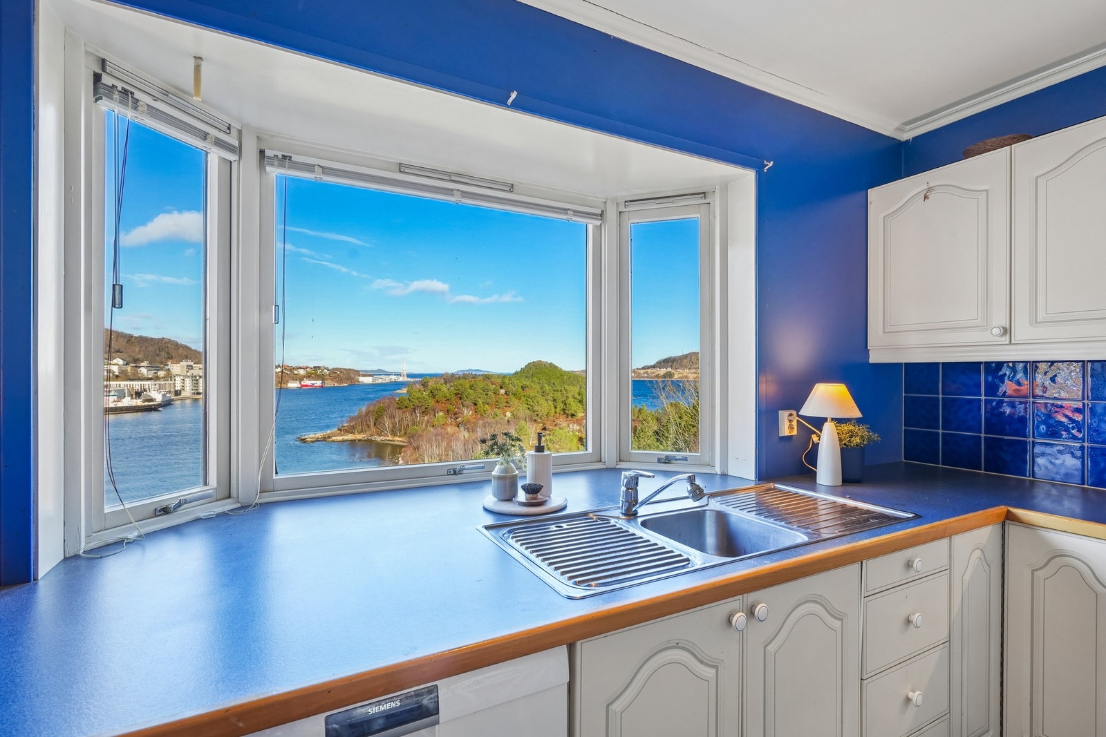 Innredningen har en overliggende oppvaskkum og belysning under overskap. Galleribilde