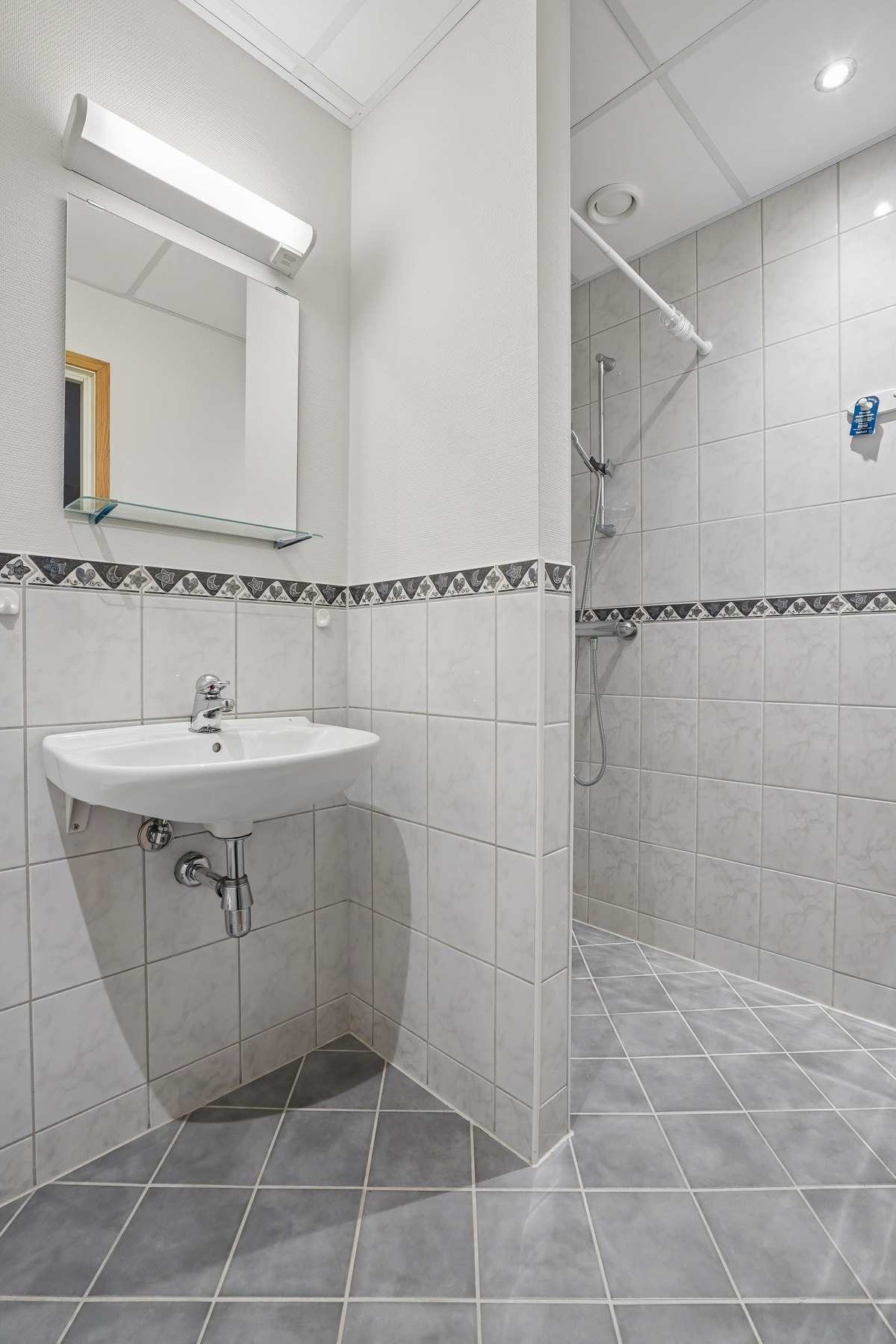 Badet er utstyrt med vegghengt toalett og servant. Speil med belysning over. Galleribilde