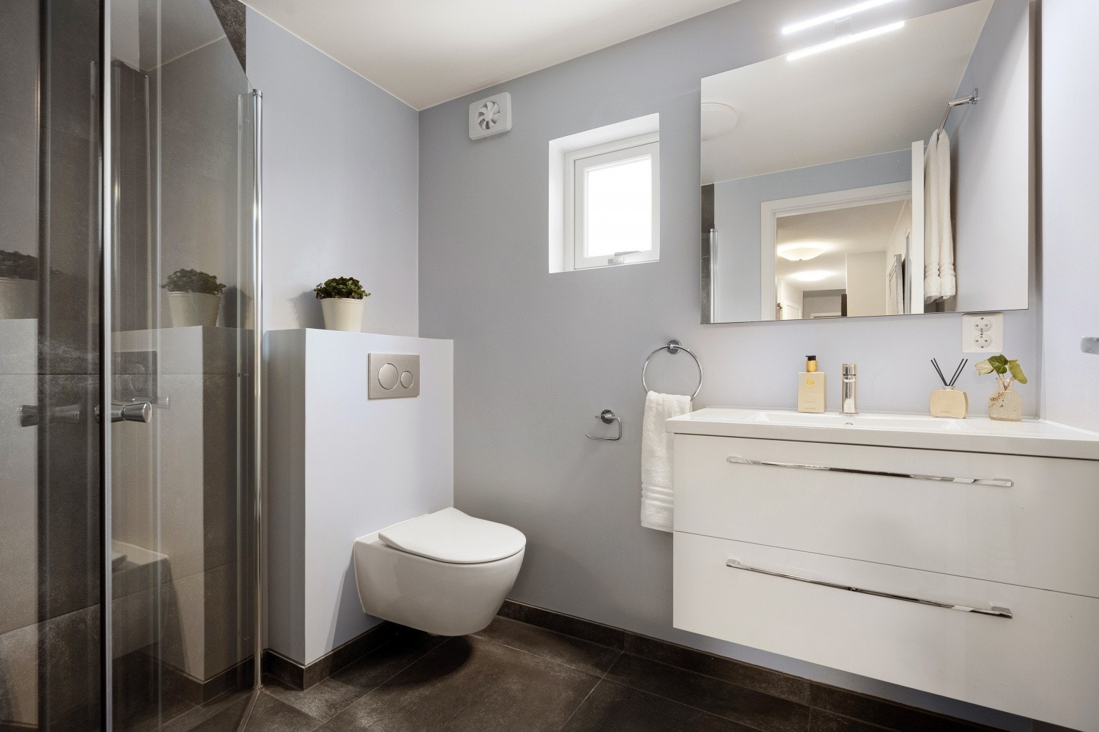 Badet et i 1.etg er fra 2021 med varmekabler i gulvet, malte plater på veggen, dusj og toalett. TG1 Galleribilde