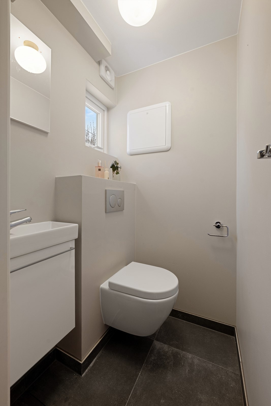 Det er også et eget gjestetoalett i 1.etg med vegghengt toalett og servant. Fliser på gulvet med varmekabler. Galleribilde