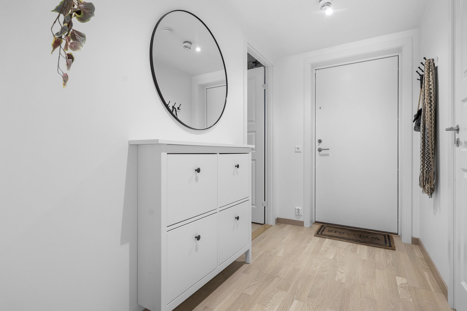 En lys entré med gjennomgående parkett ønsker velkommen inn. Galleribilde