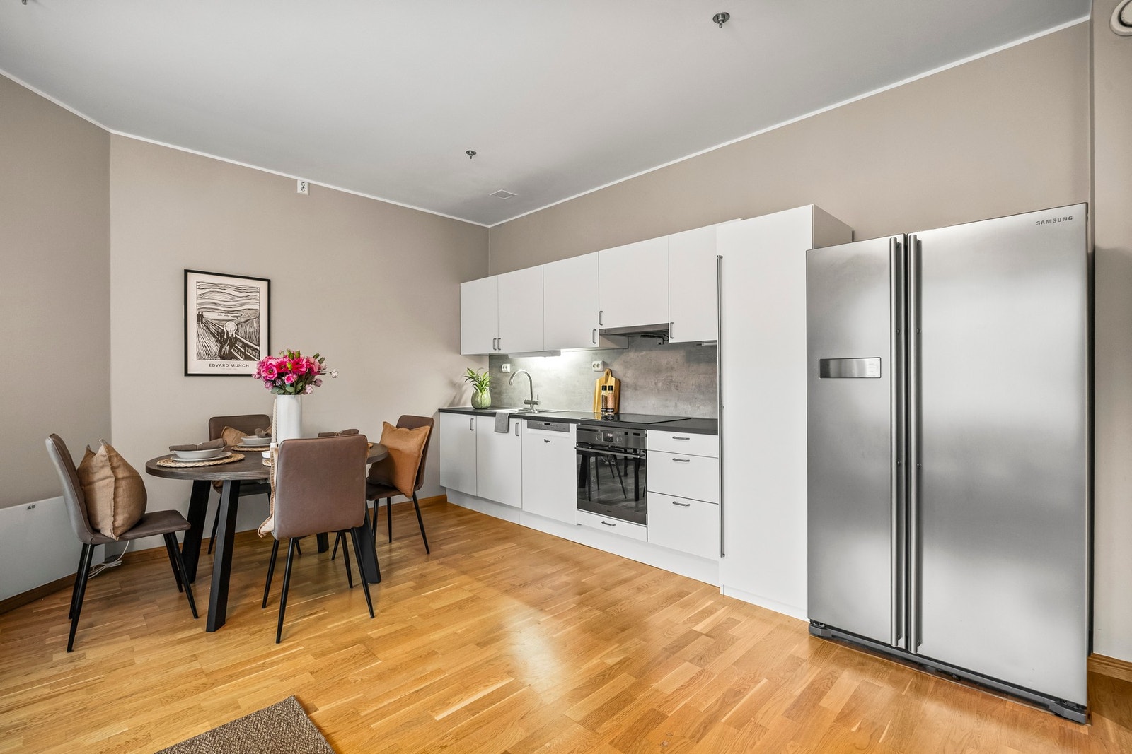 Kjøkkeninnredningen består av hvite og glatte skapfronter. Integrert platetopp og stekeovn. Galleribilde