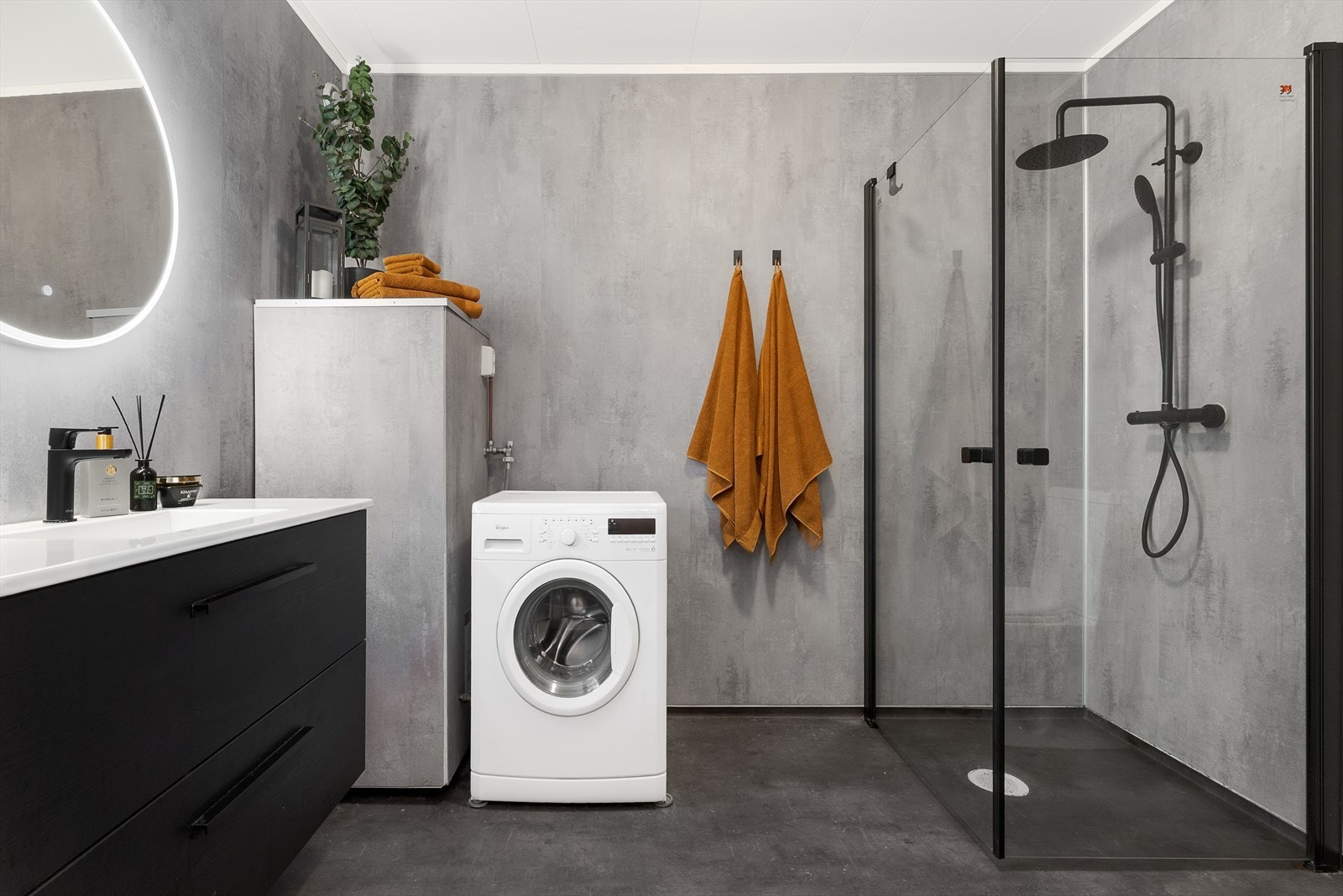 Badet er utstyrt med dusjhjørne, toalett, romslig innredning, servant og opplegg for vaskemaskin. Galleribilde
