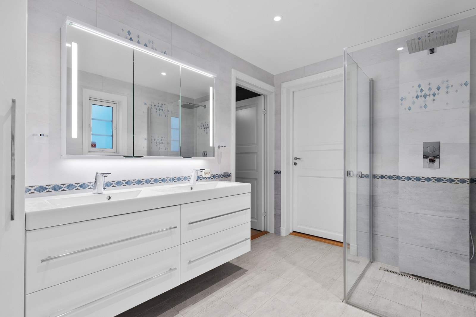 Badet har romslig innredning og dusj med stillbare glassdører Galleribilde