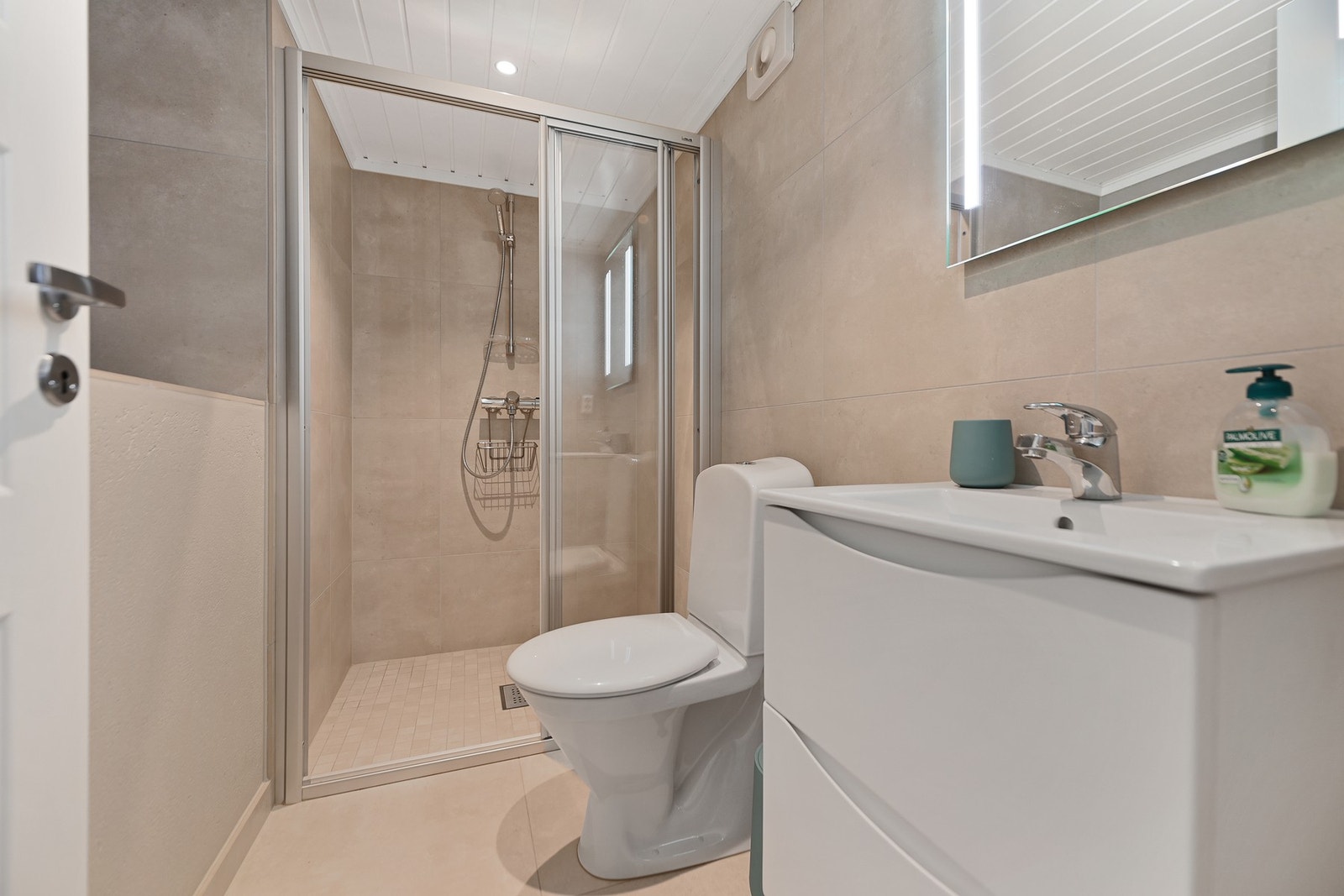 Badet har gulvstående wc, servantskap med speil og dusjnisje, samt varmekabler i gulvet. Galleribilde