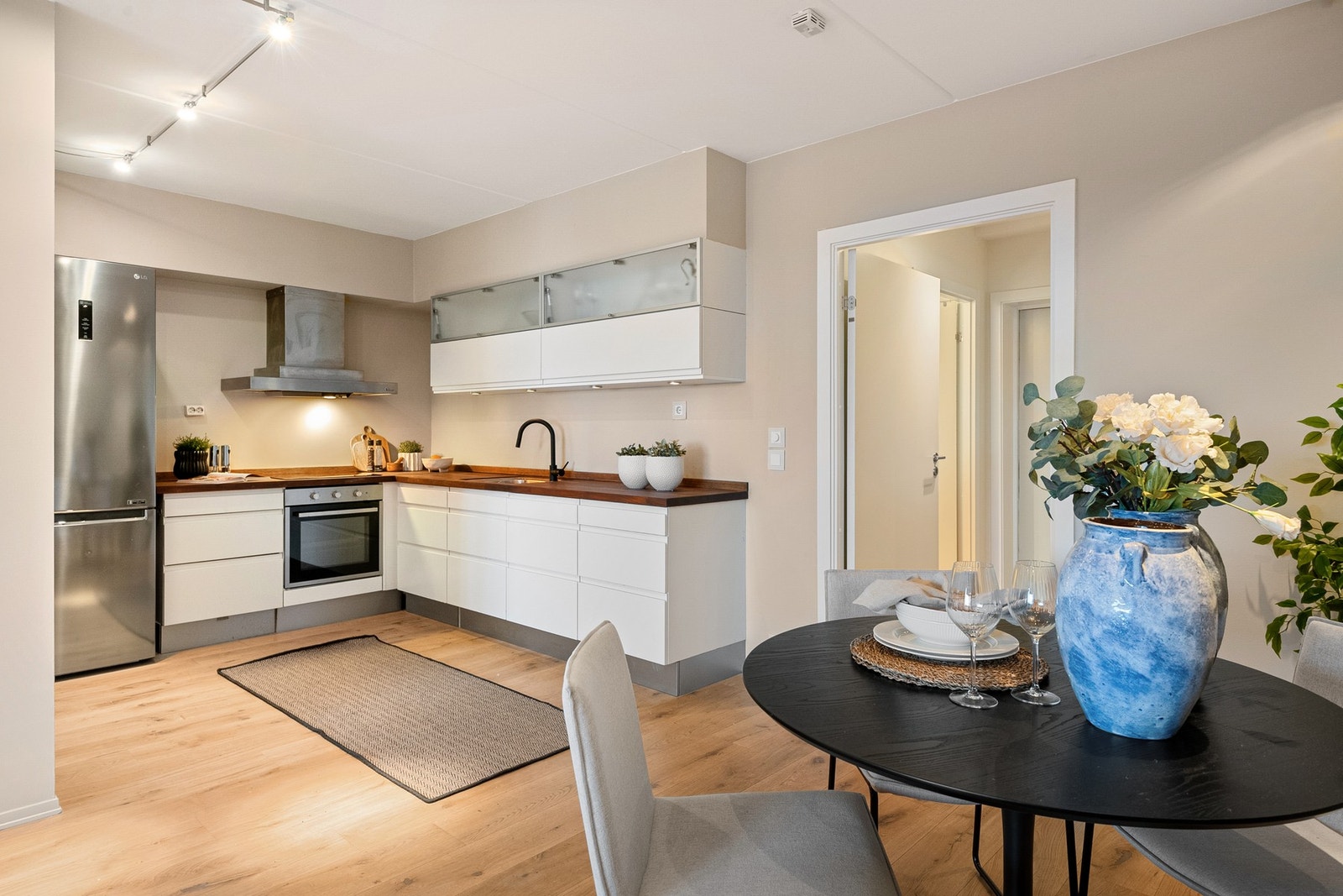 Kjøkkenet har en stilren innredning med glatte fronter og heltre benkeplate med planlimt kum i rustfritt stål. Galleribilde