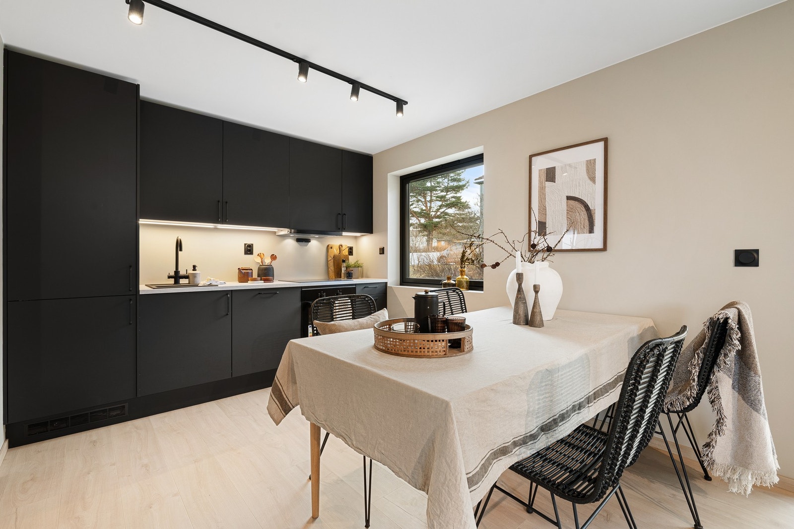 Leiligheten er renovert i en moderne stil med glatte overflater i en tidsriktig fargetone, moderne spotskinner og sorte detaljer gjennomgående. Galleribilde