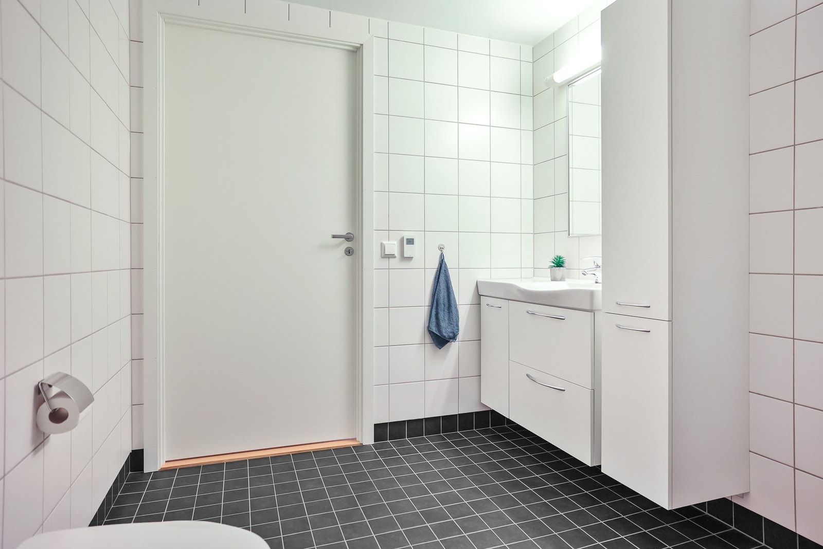 Det er dusjhjørne med dører, vegghengt toalett og opplegg for vaskemaskin. Galleribilde