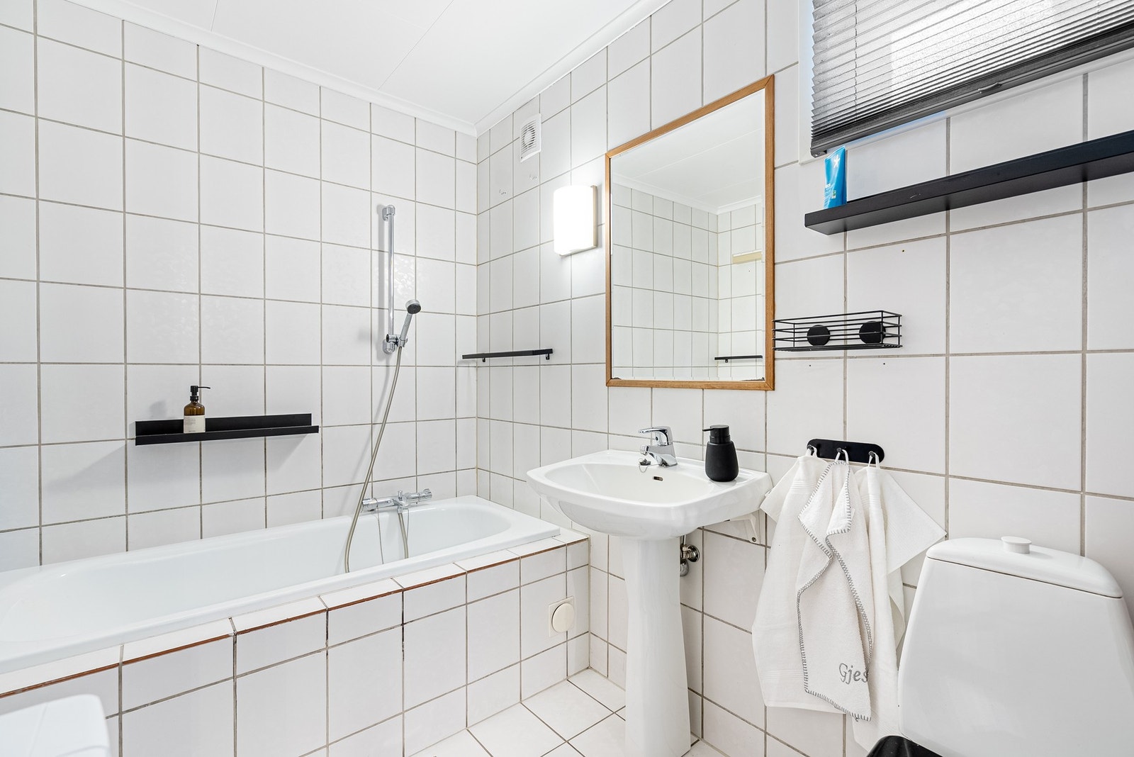Helfliset bad med badekar, servant og toalett - et rom for både avslapning og praktisk bruk Galleribilde