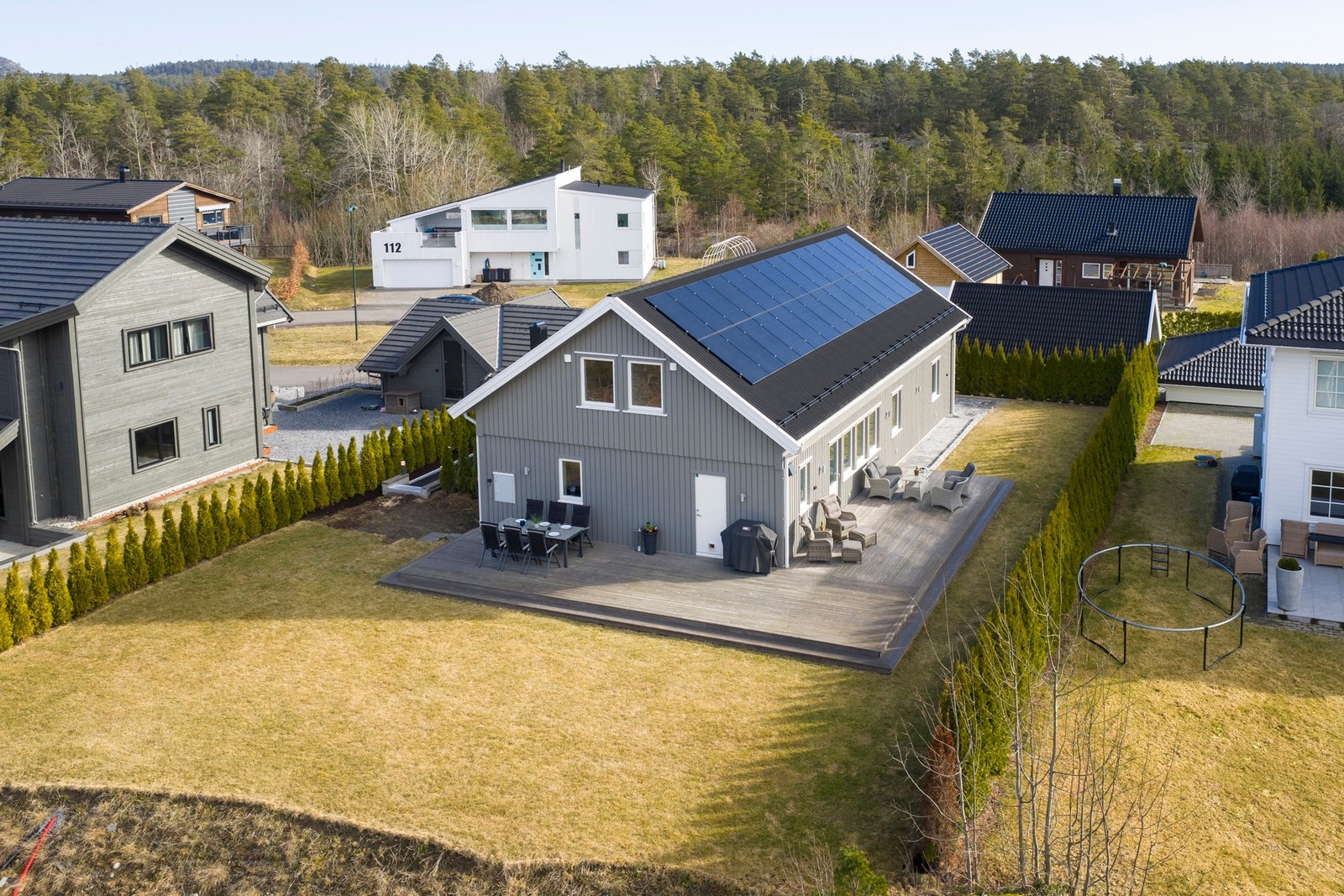Her ser vi fasaden mot vest. Stor terrasse og direkte adgang til hage. Her er det meget solrikt, med kveldssol til nærmere kl 22 om sommeren. Galleribilde