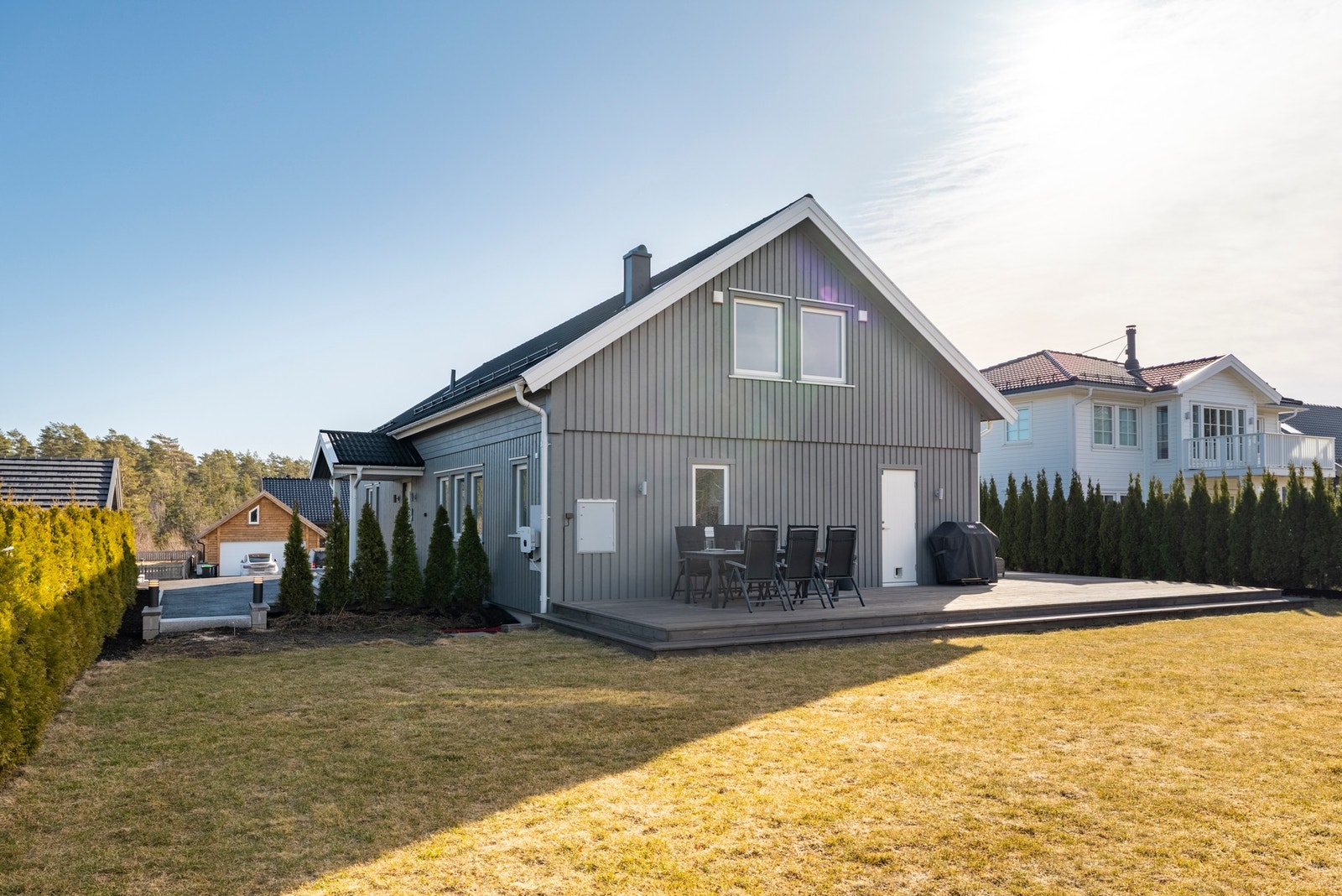 Romslig hage med diverse beplantning og stor terrasse. Galleribilde