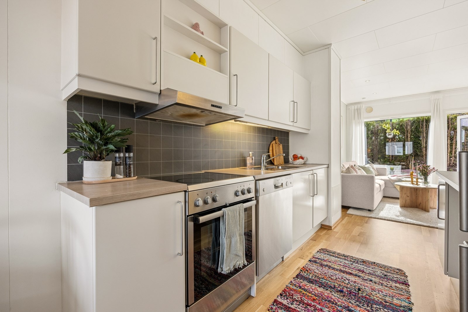 Kjøkkeninnredning fra byggeåret med slette fronter, laminatbenkeplate og fliser over benken. Galleribilde