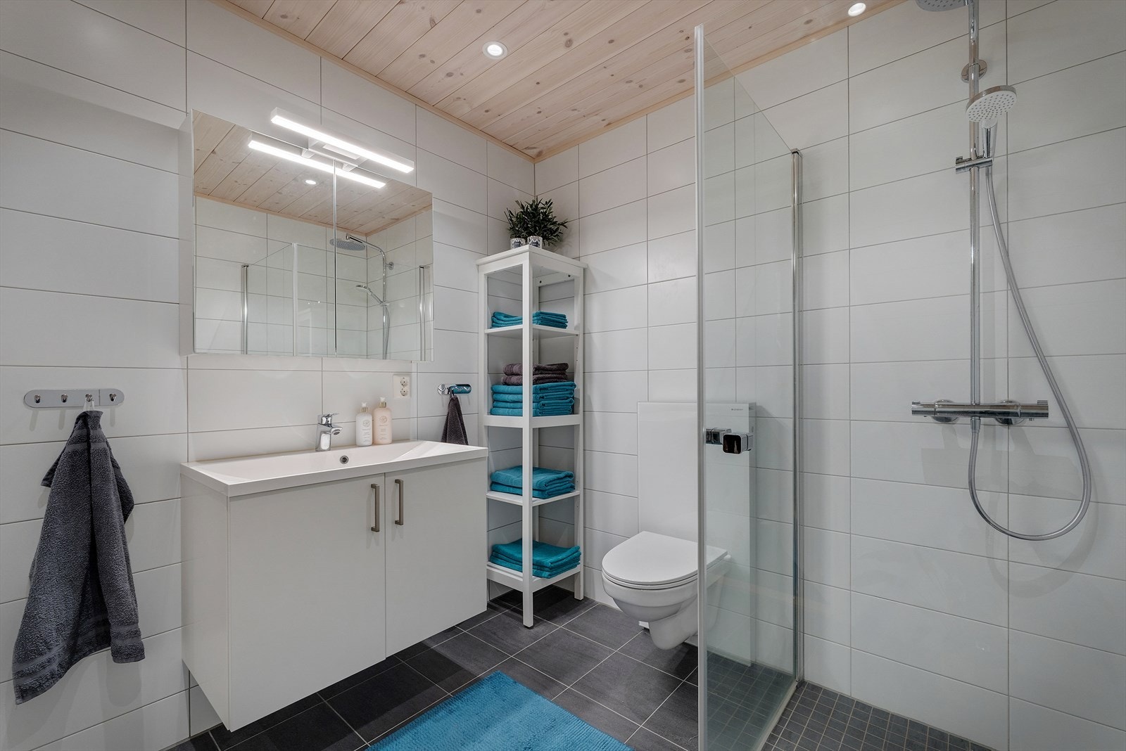 Baderommet er et moderne bad med lyse overflater overflater med fliser på gulv og vegger - vannbåren varme i gulvet Galleribilde