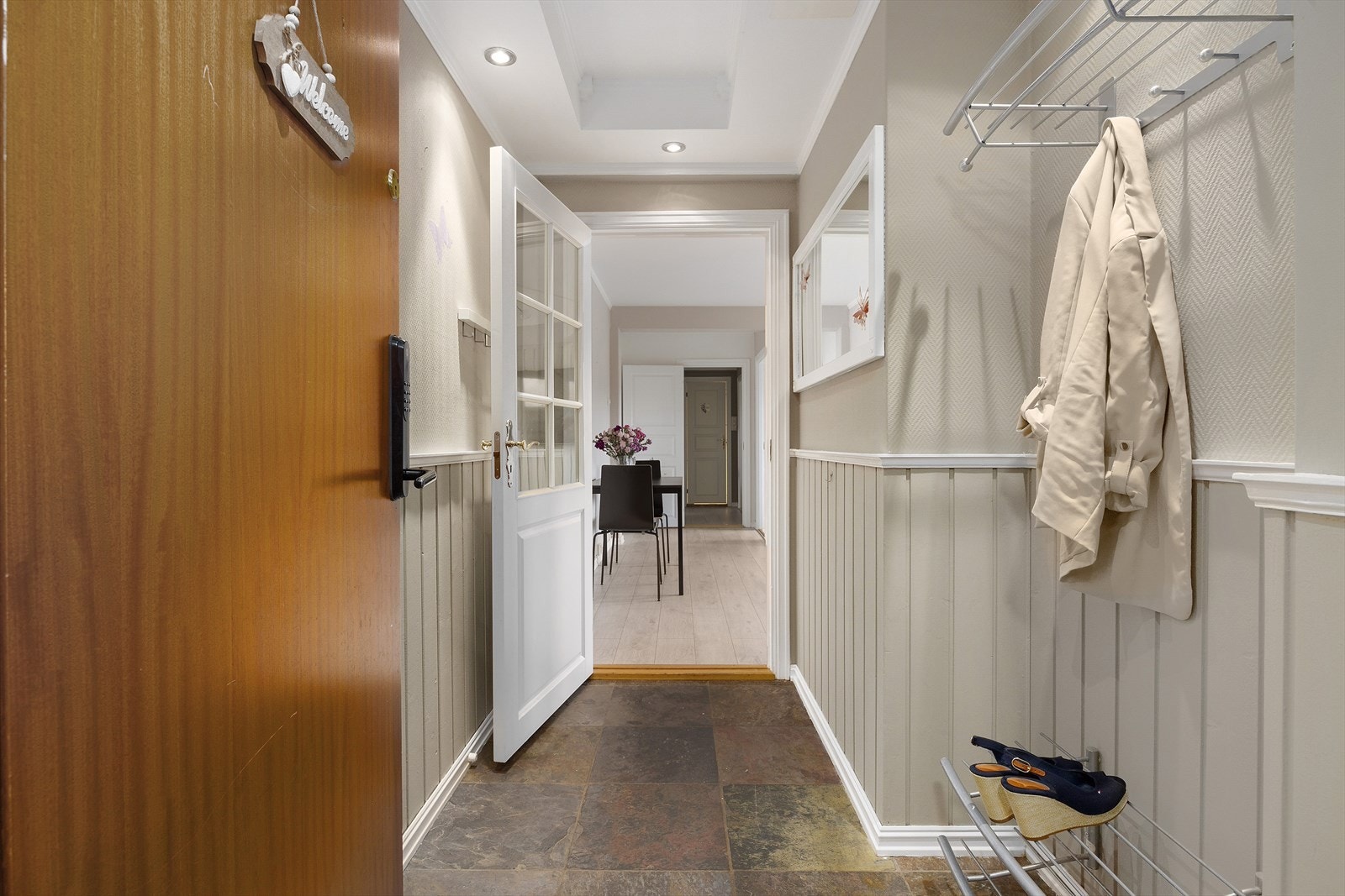 Velkommen inn i en innbydende entré med flislagt gulv, som er både praktisk og slitesterkt. Her er det gode oppbevaringsmuligheter med plass til skoskap og knaggrekke for yttertøy. Galleribilde