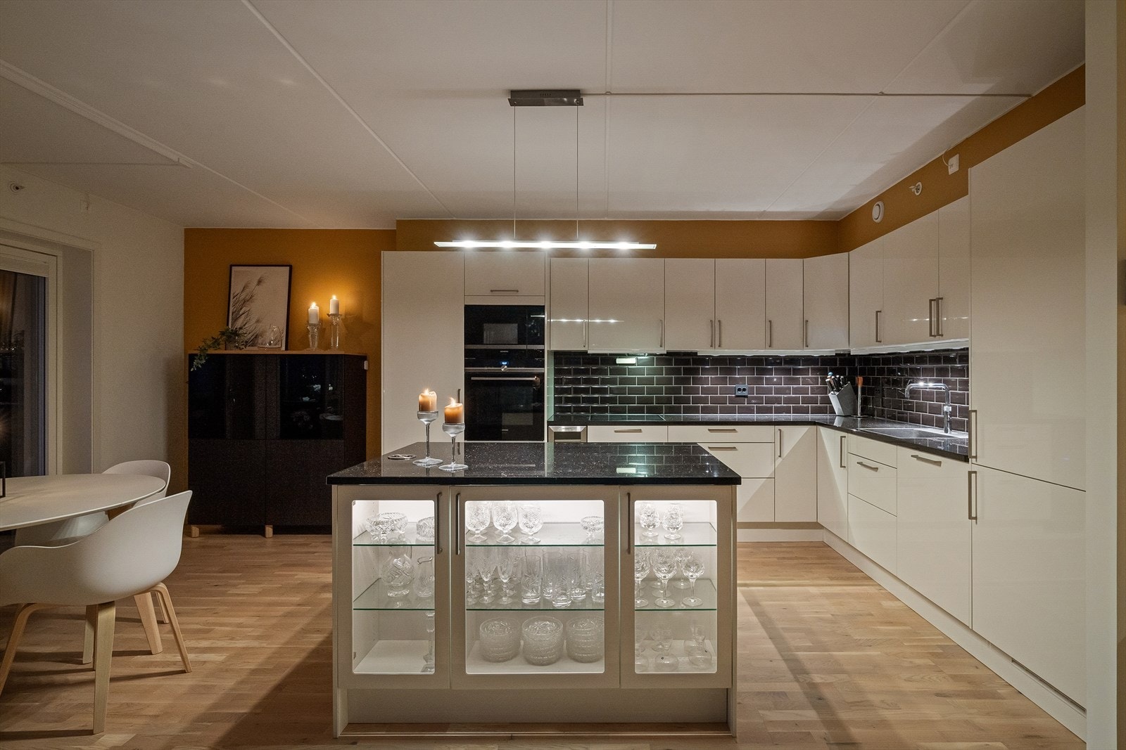 Kjøkkenet har et stilrent design og en funksjonell kjøkkenøy som gir både ekstra arbeidsplass og en sosial sone. Galleribilde