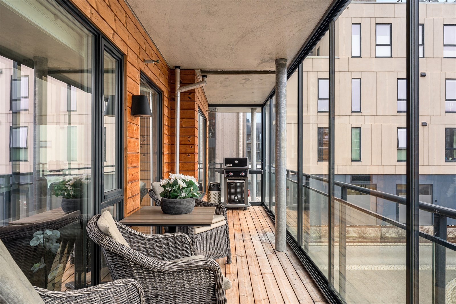 Stor, vinkelformet balkong med plass til sittegruppe og grill. Galleribilde