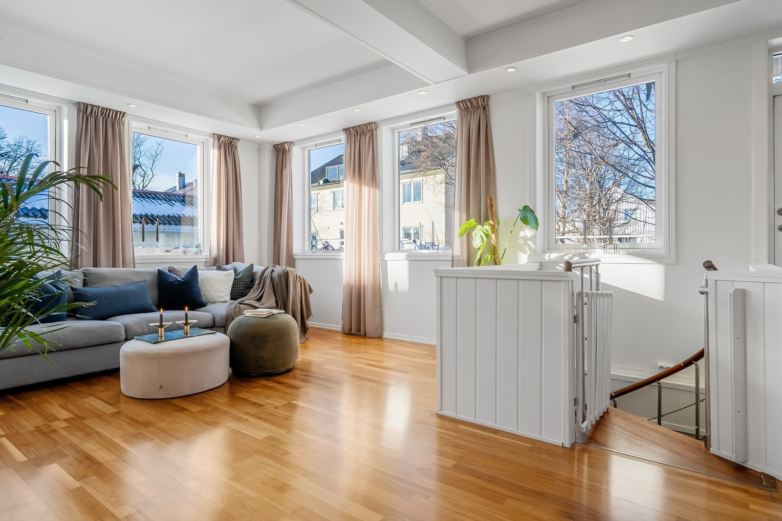 Lys og innbydende stue med store vindusflater Galleribilde