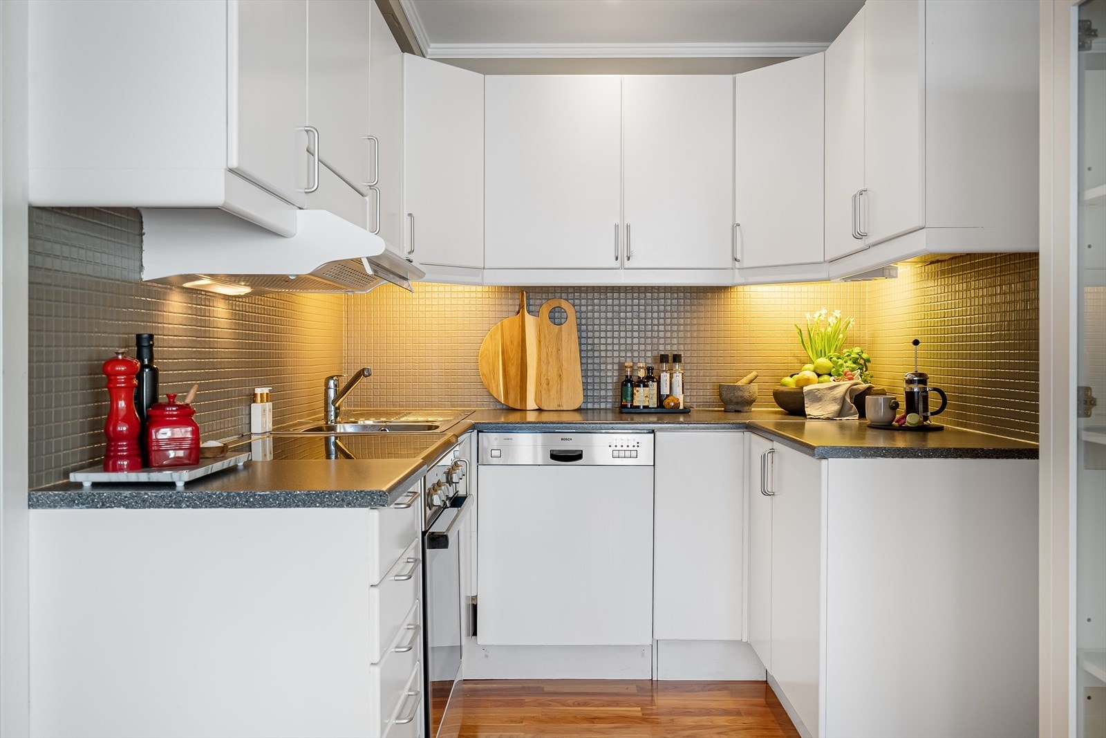 Koselig kjøkken med hvite fronter og laminat benkeplate. Galleribilde