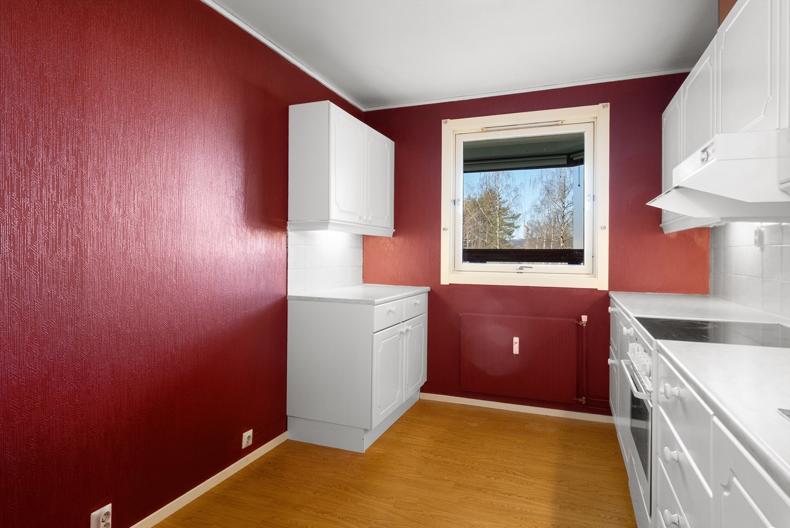 Kjøkkenet har en innredning med malte og profilerte fronter, og en laminert benkeplate med nedfelt vaskekum. Galleribilde