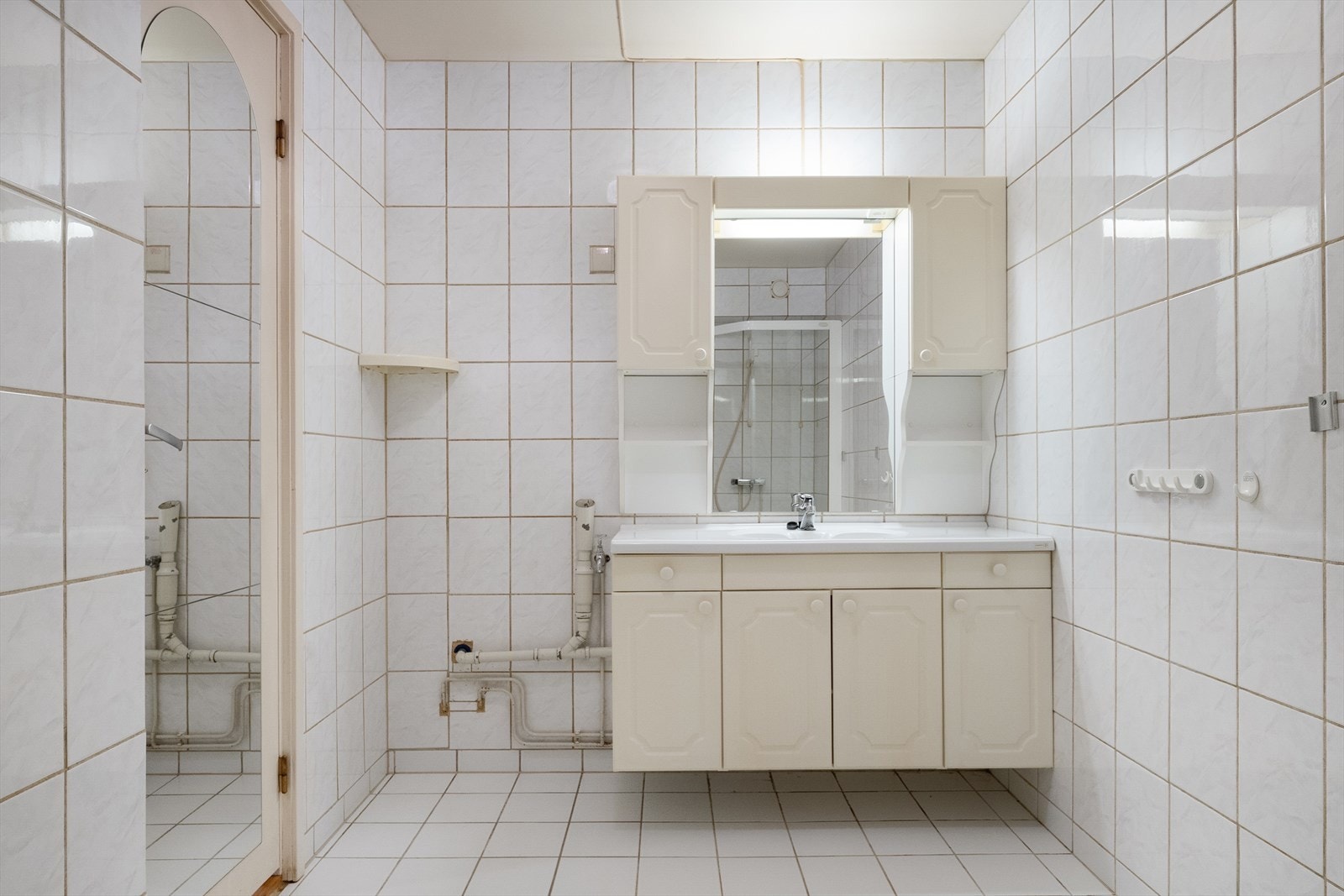 Badet er av god størrelse og har flislagte overflater på gulv og vegger, samt malt himling. Galleribilde