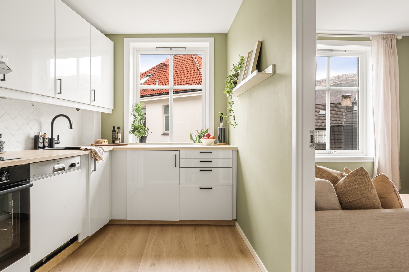 Kjøkkeninnredning med slette fronter og laminat benkeplate med nedfelt vask av kompositt. Galleribilde